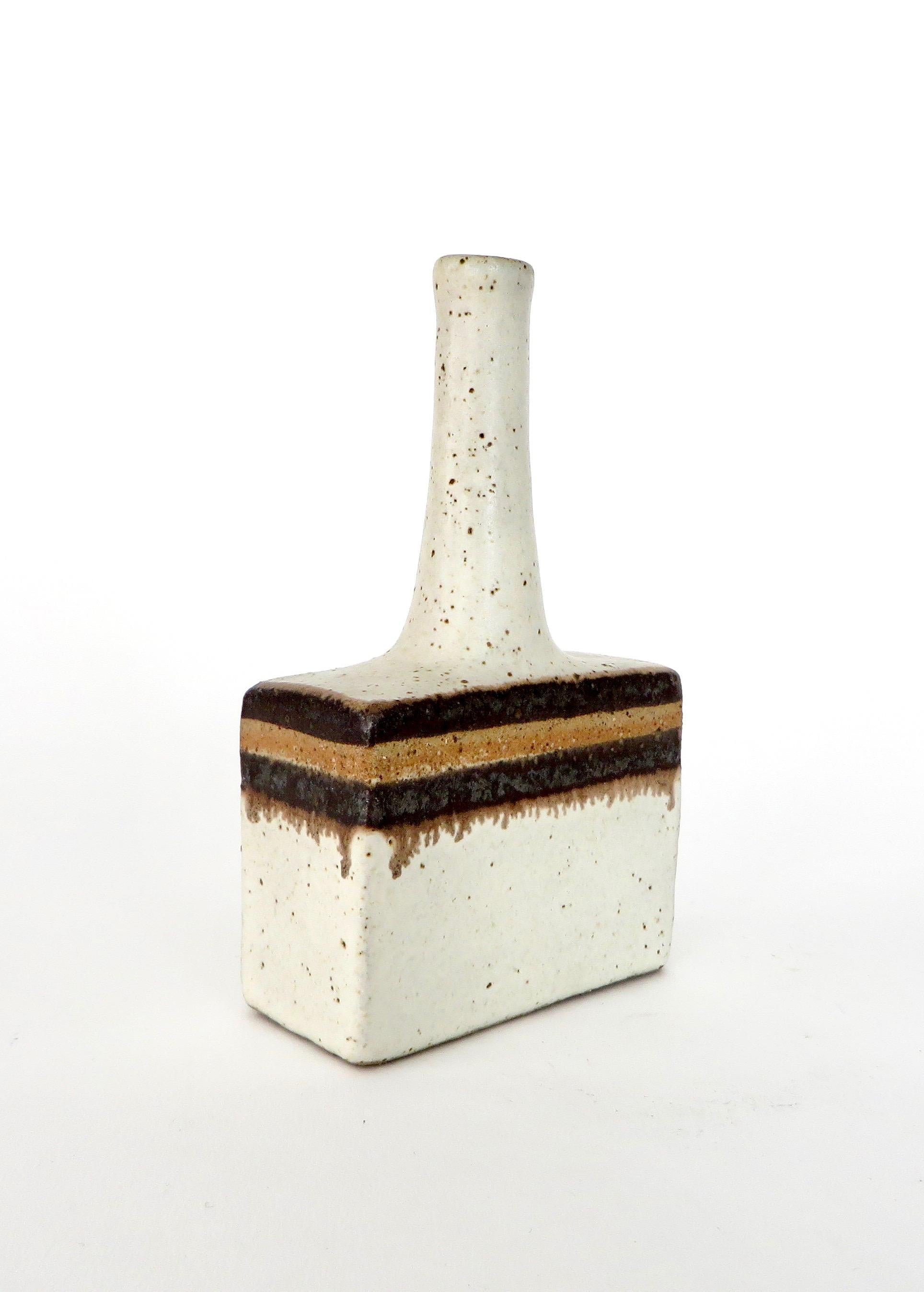 Bruno Gambone decorative ceramic mini bottle-shaped vessel with chalk-white surface and chocolate and light brown glazed ribbon motif by (circa 1970s). With a modern rectangular base and lean, elongated neck its shape and finish have their origins