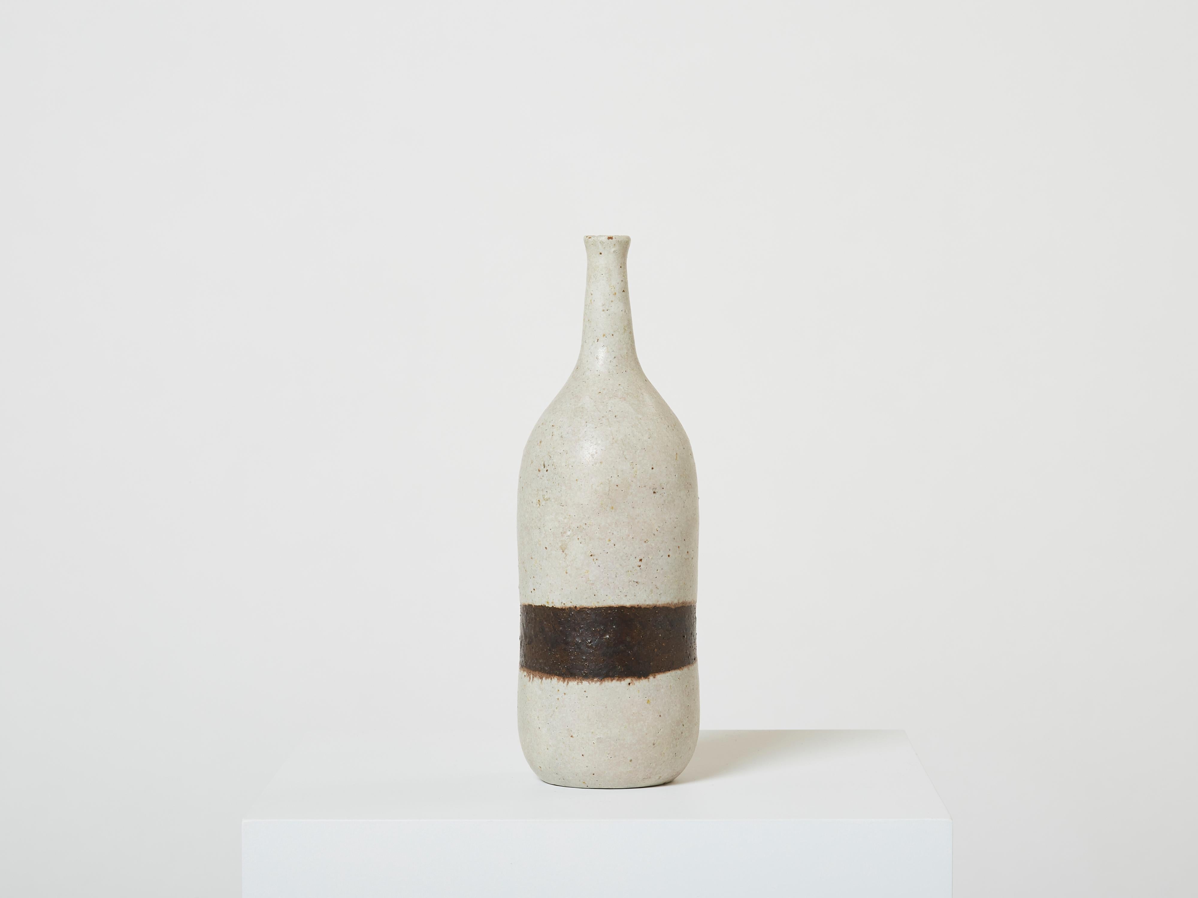 Magnifique vase à fleur unique en grès émaillé gris de Bruno Gambone, en forme de bouteille, réalisé au milieu des années 1970. Ce magnifique vase est typique du design minimaliste de Bruno Gambone, avec une seule ligne brune. Bruno est retourné à