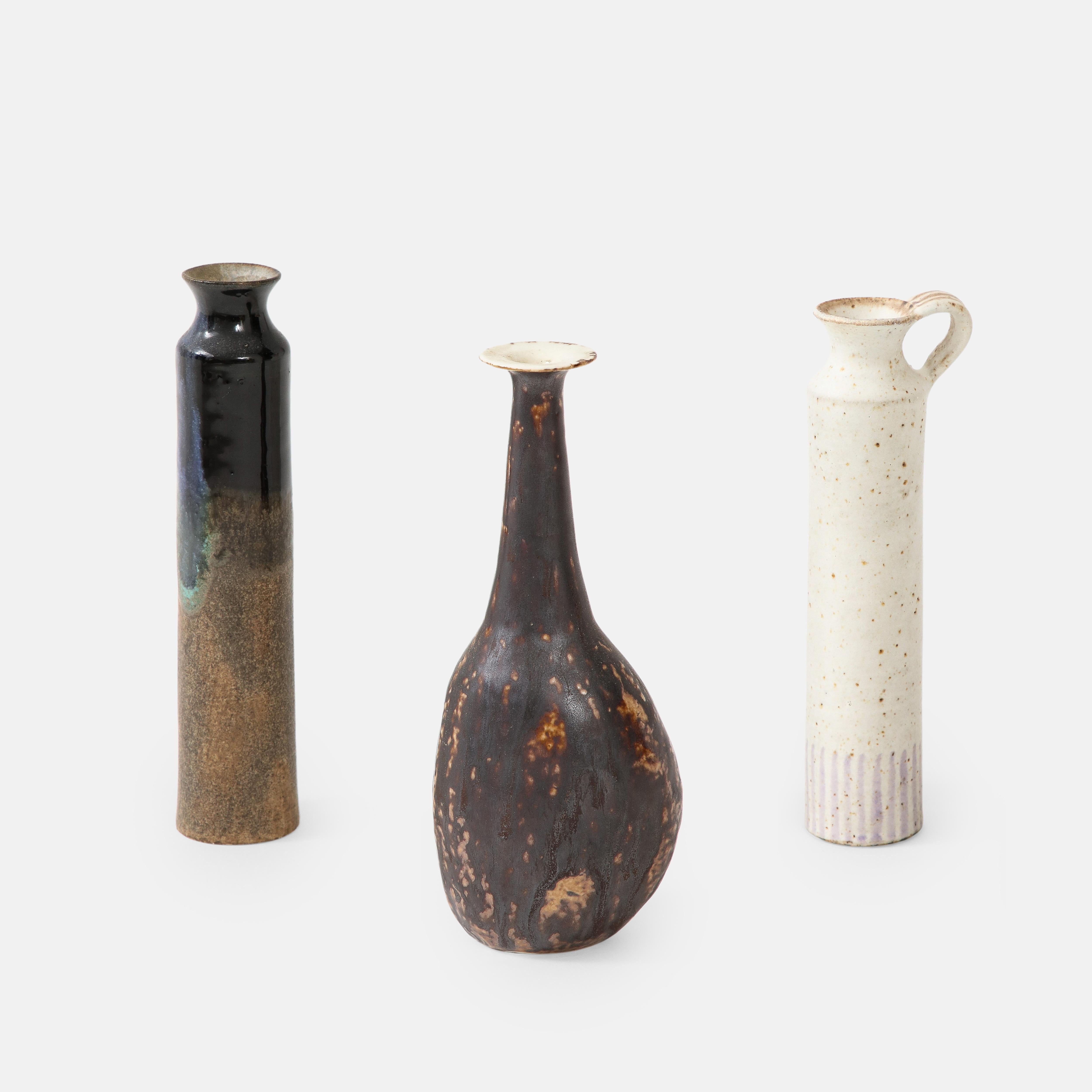 Bruno Gambone set of three small stoneware or ceramic vases or vessels, Italy, 1970s.   This beautiful set of small stoneware vases are grouped together nicely with contrasting and complimentary colored glazes and shapes but in similar sizes. 
