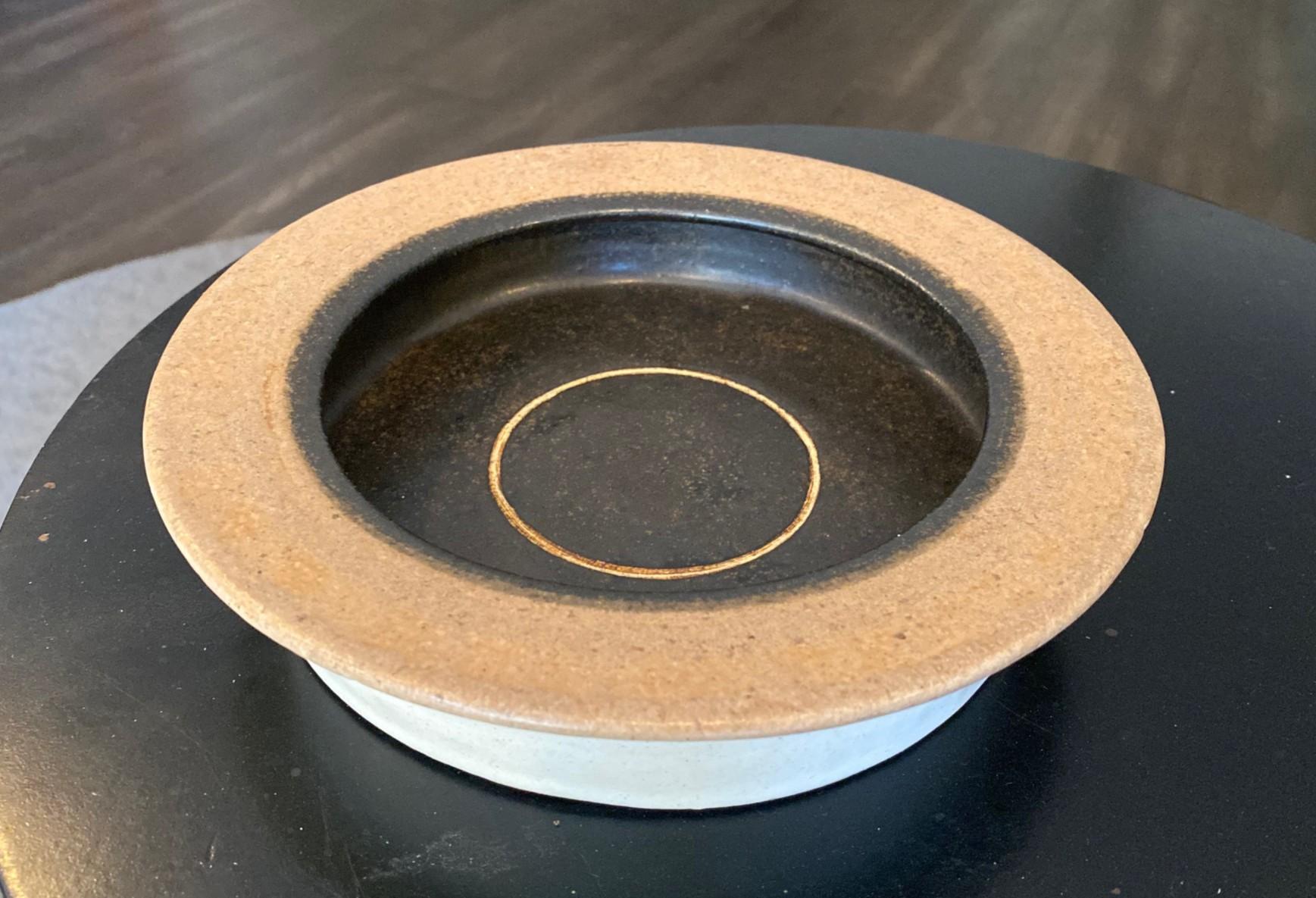 A wonderfully shaped and glazed stoneware bowl by Italian master potter/ceramicist Bruno Gambone, the son of legendary artist Guido Gambone.  Glazed beautifully with a off white and black/brown glaze with a simple two tone circular design.

The bowl
