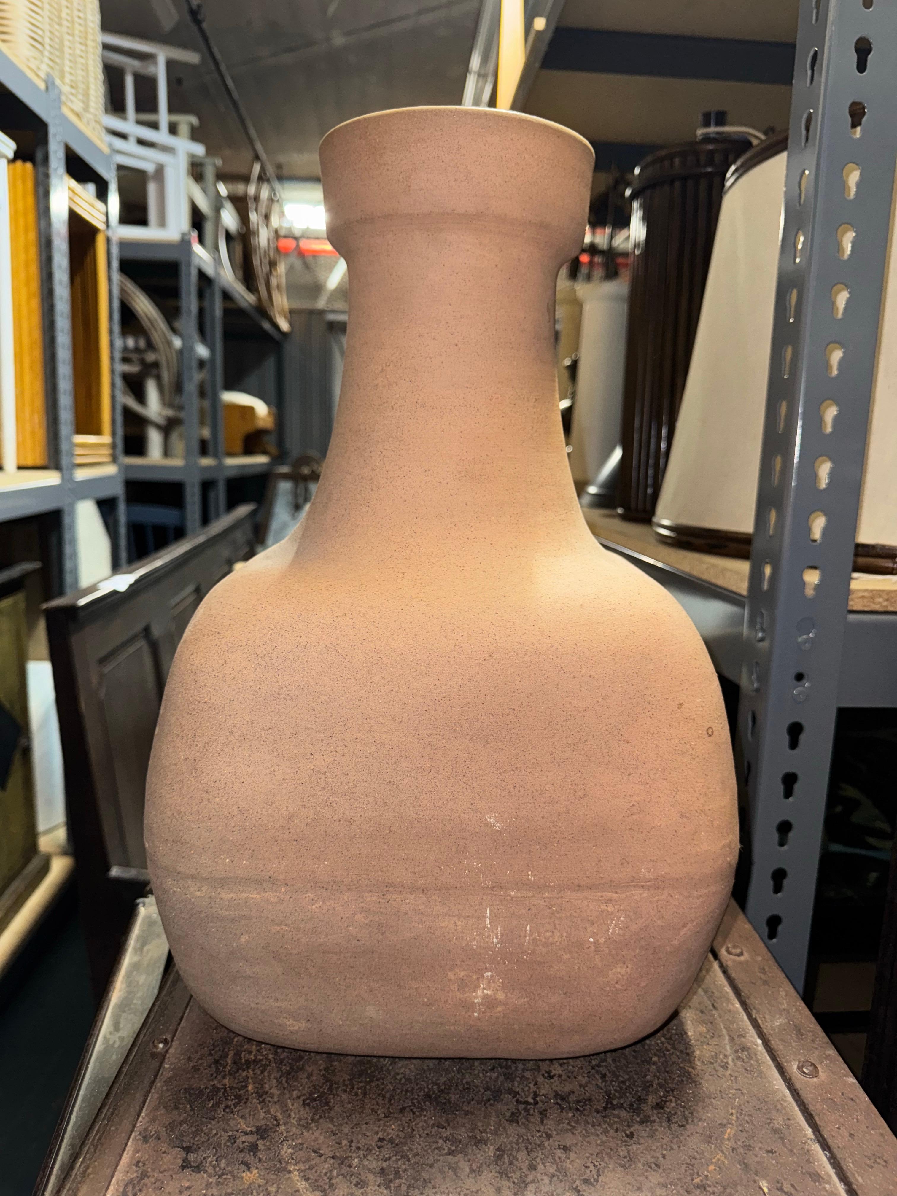 A substantial stoneware vase by Bruno Gambone, demonstrating the sculptural restraint and material sensitivity characteristic of the artist’s mature production. The form is defined by a broad, softly squared body that rises into a pronounced
