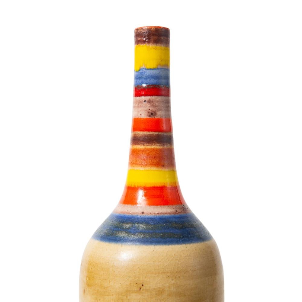 Vase Bruno Gambone, céramique, Rayures, Signé. Vase de taille moyenne en forme de bouteille élancée avec un corps glacé amande neutre et un col glacé en bandes de jaune, rouge et bleu. Signé 
