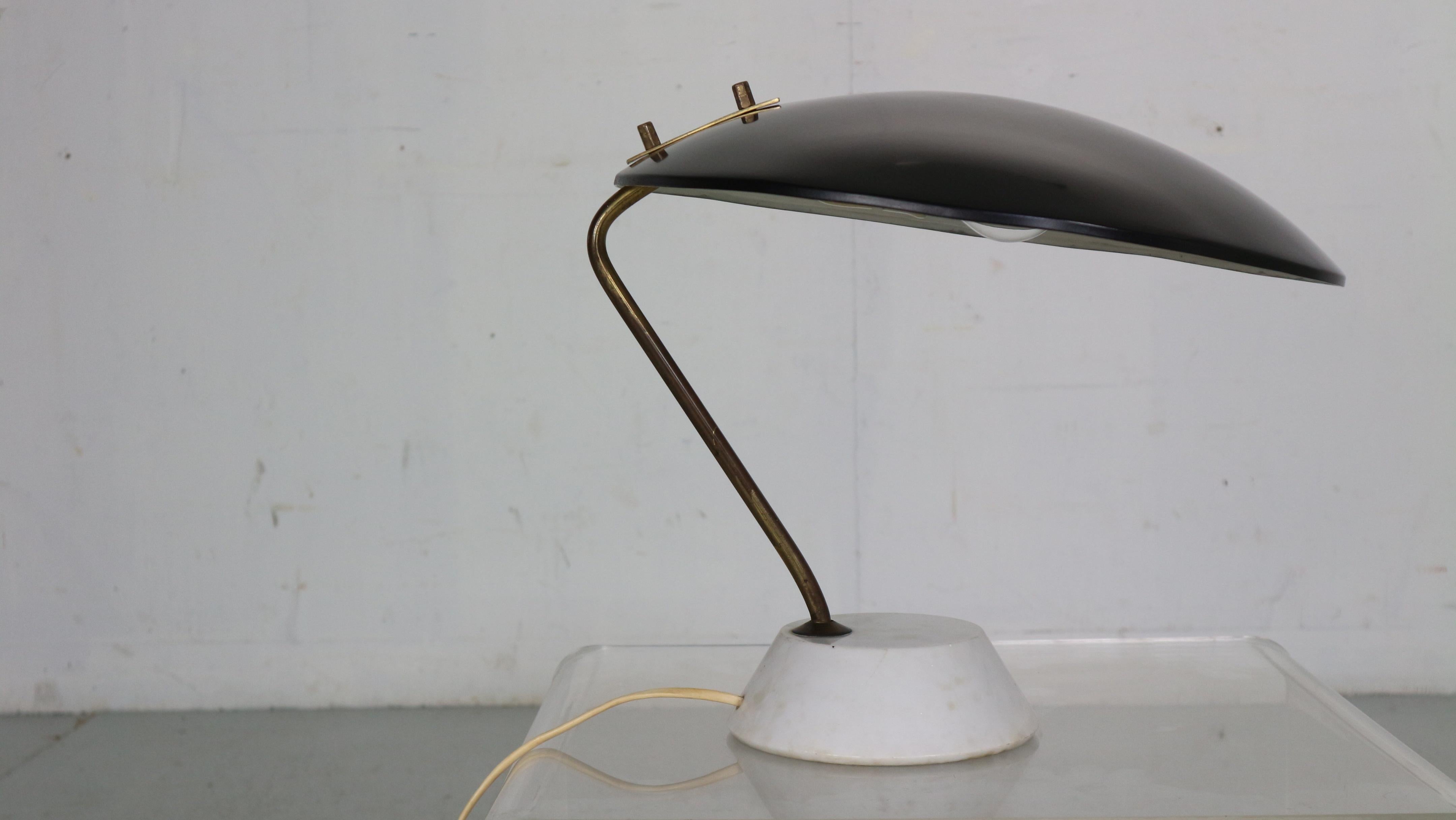 Elegant table light designed by Bruno Gatta and manufactured for Stilnovo in 1960's Italy.
This table light features a black lacquered aluminium shade with a brass rod on a white carrara marble base.

We choose for it not to polish the brass and