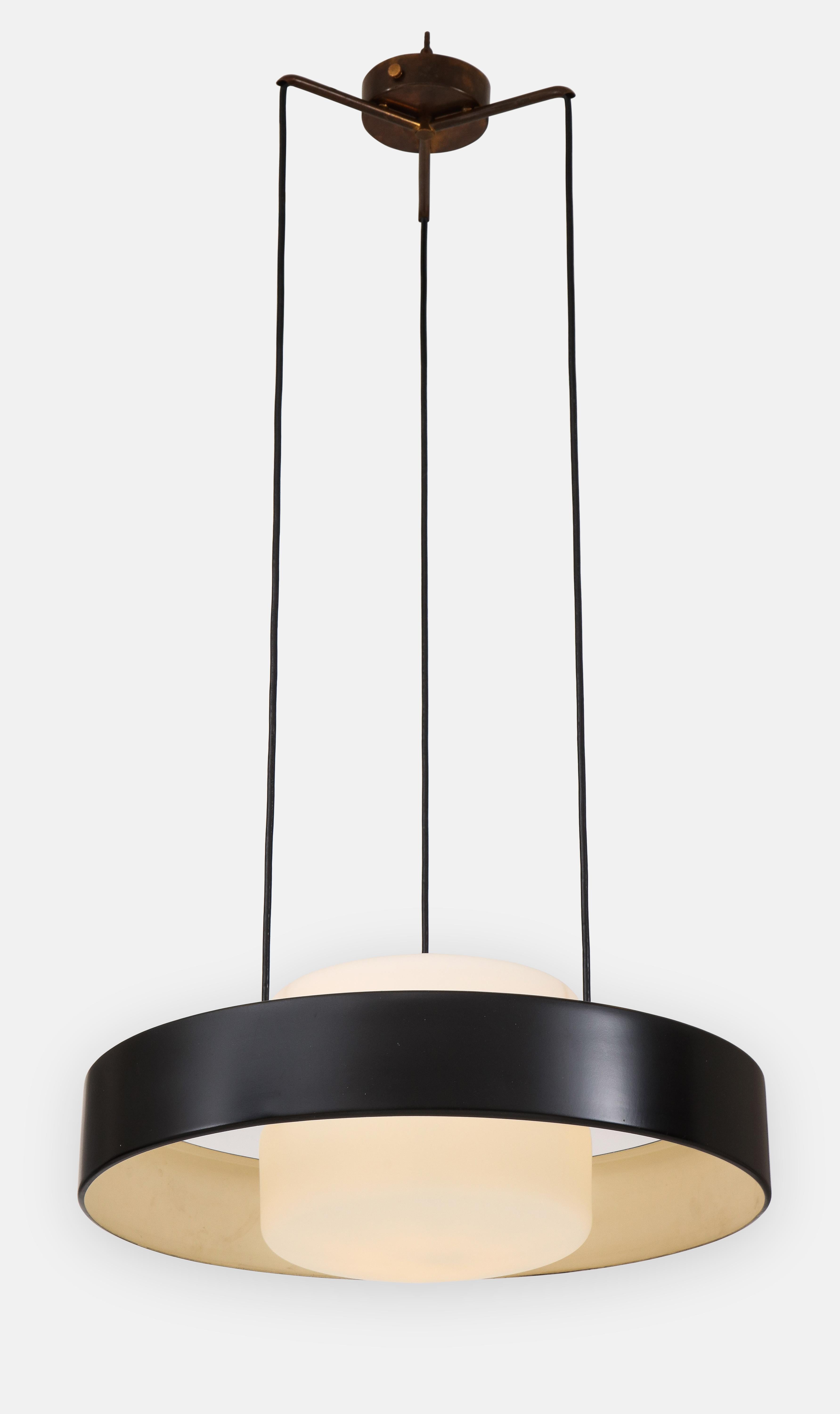 Stilnovo iconic suspension or pendant light model 1158 composed of black enameled metal ring and opaque glass shades suspended from original brass canopy and structure, Italy, 1960s. This adjustable chandelier or pendant emits light beautifully with