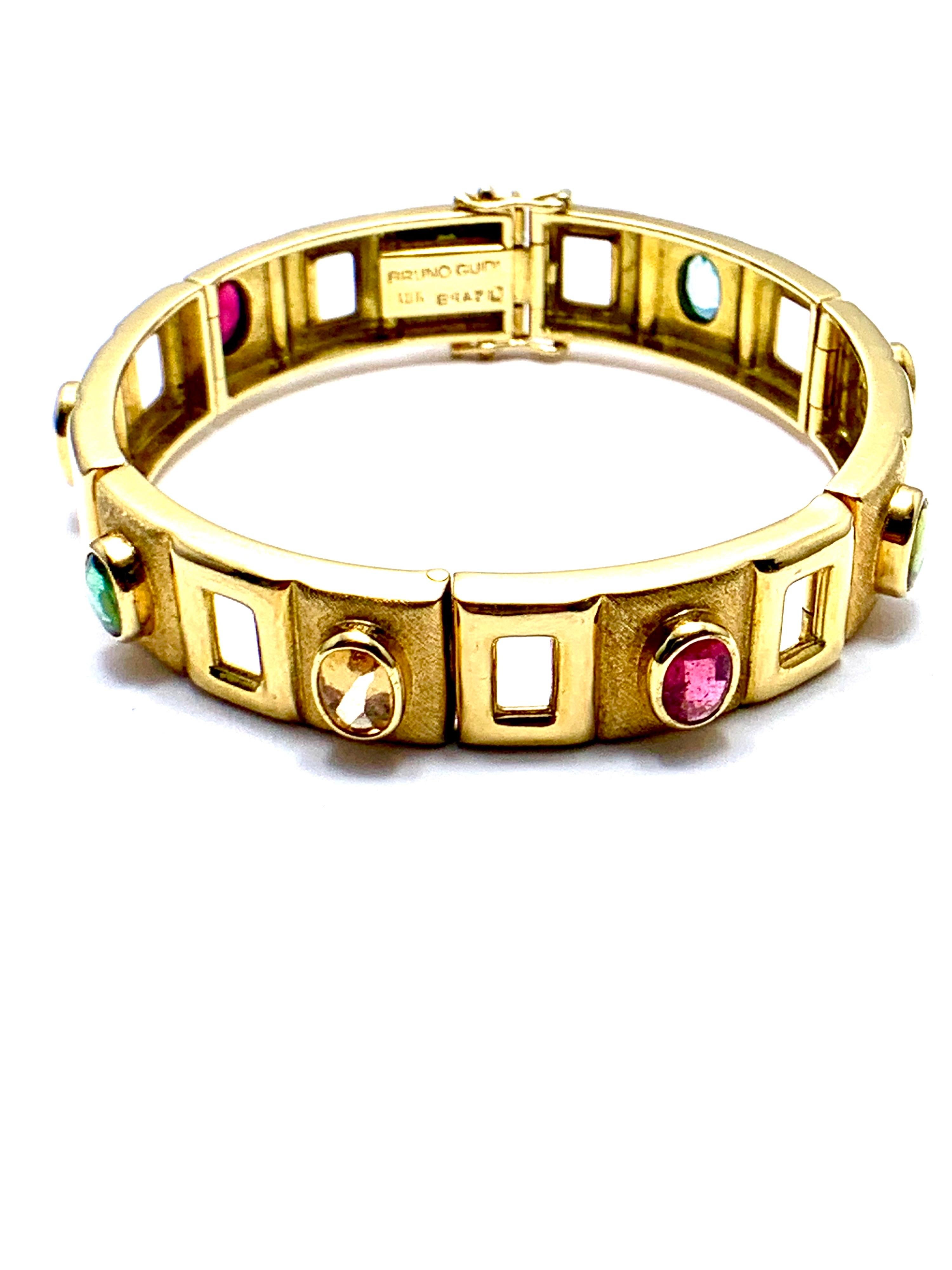 A rare to find Bruno Guidi Retro 18K yellow gold bracelet.  The bracelet is designed with oval cabochon gemstones individually bezel set in brushed rectangular links alternating with openwork polished links.  The gemstones used are Aquamarine,