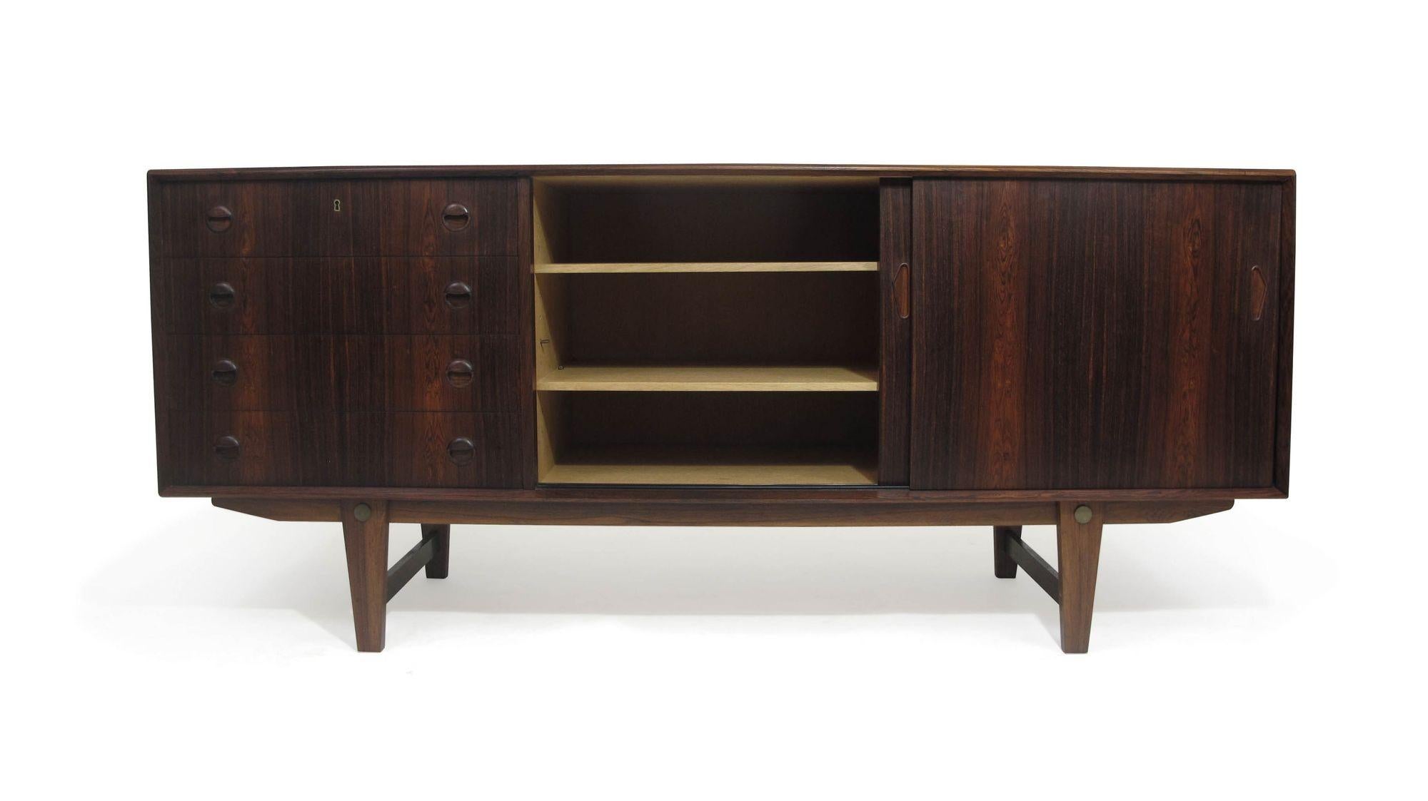 Finely crafted Brazilian rosewood credenza attributed to Bruno Hansen, Denmark, 1955. Features beveled edges, mitered corners, and stunning book-matched grain patterns across the front. Four drawers in center with locking top drawer, and sliding