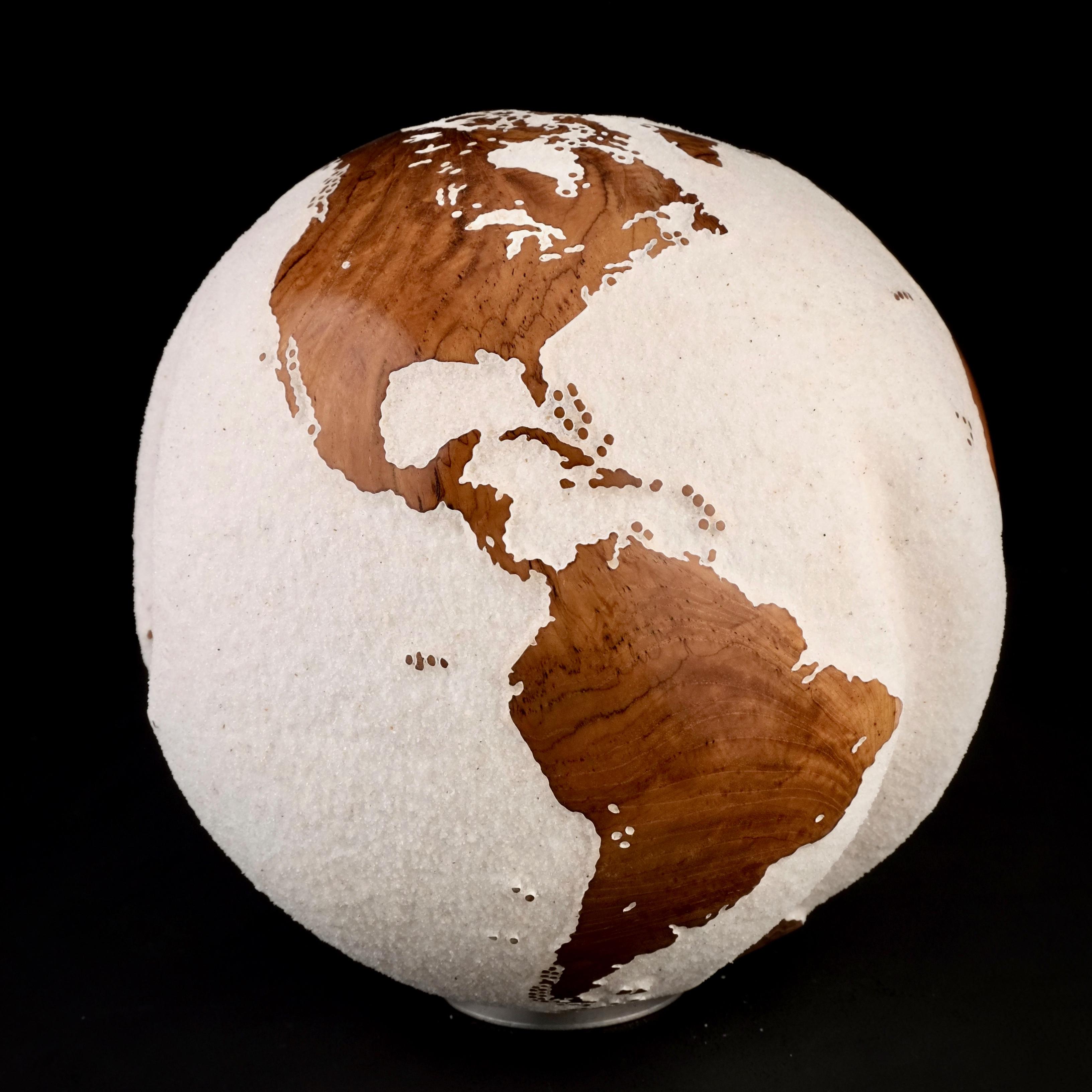 Teakwood and white lava sand make this beautiful turning globe a real stunning sculpture.
Made from a whole piece of wood the way the sculpture is shaped is defined by how the tree grew.
Sitting on a turning base the sculpture can spin silently