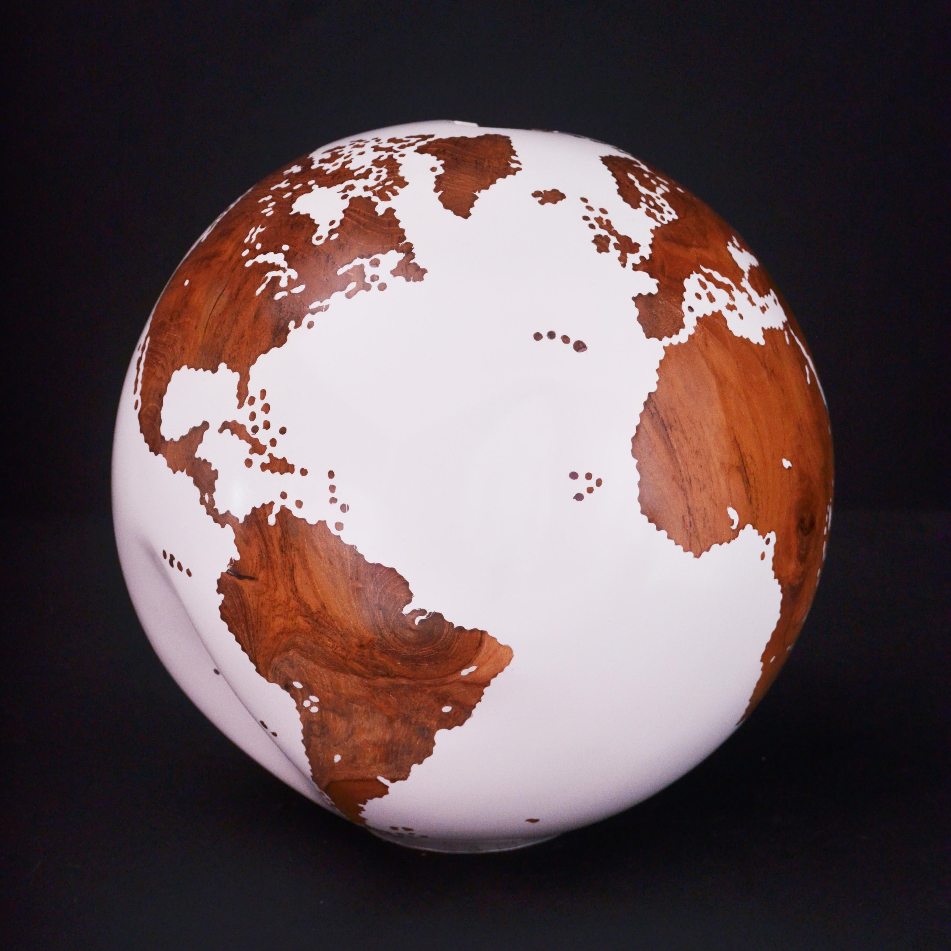 Teakwood and white make this beautiful turning globe a real stunning sculpture.
Made from a whole piece of wood the way the sculpture is shaped is defined by how the tree grew.
Sitting on a turning base the sculpture can spin silently around, so