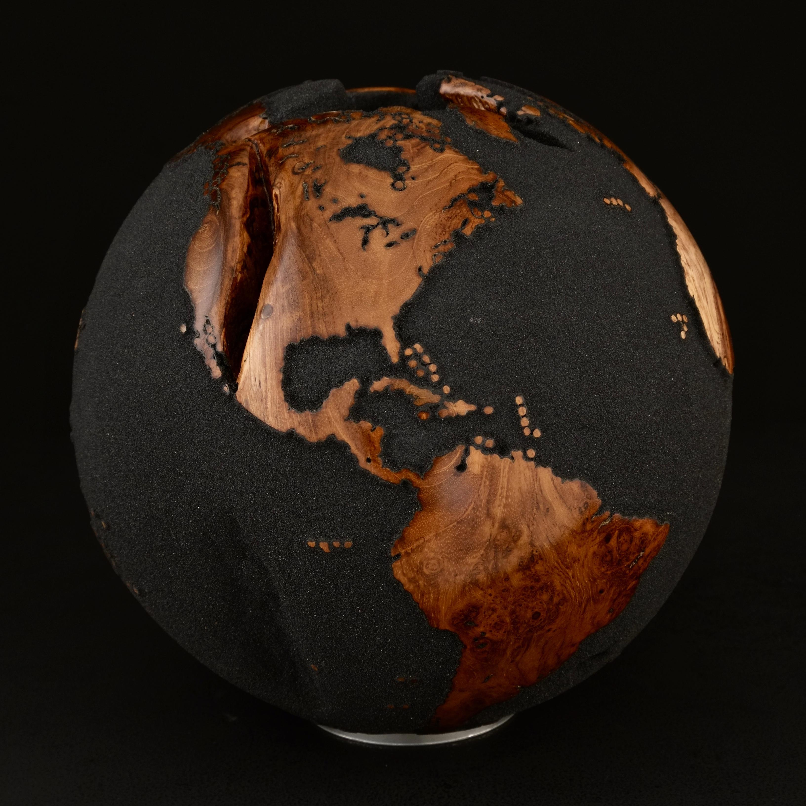 Le bois de teck et le sable de lave noir font de ce magnifique globe tournant une véritable sculpture.
Réalisée à partir d'un morceau de bois entier, la sculpture est façonnée en fonction de la croissance de l'arbre.
Posée sur un socle tournant, la