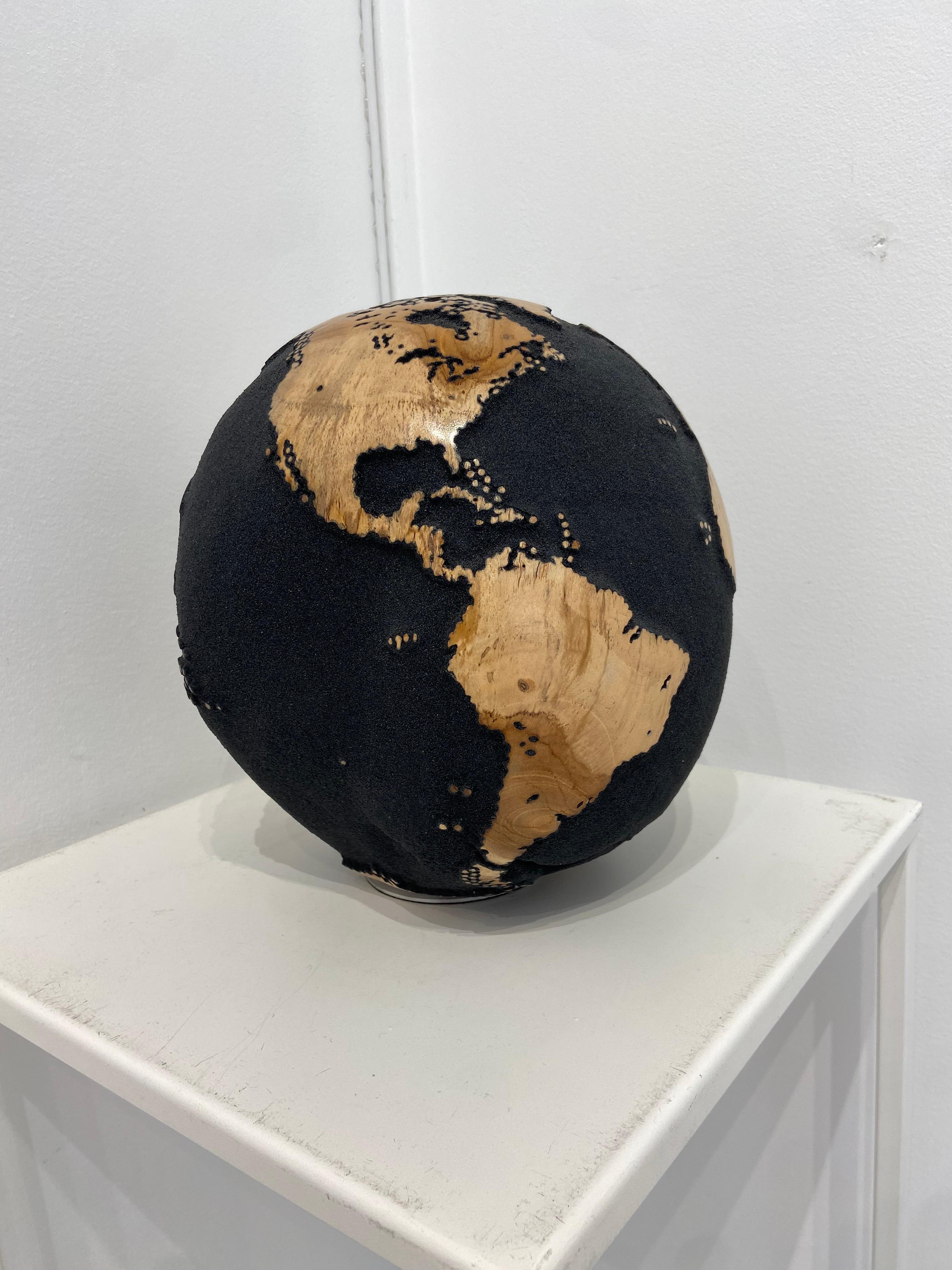 Ce globe tournant fait de bois de teck recyclé et de sable volcanique noir issu des plages de Bali, est le reflet exact de la représentation que se fait Helgen de la répartition géographique du monde et de ses causes naturelles, environnementales et