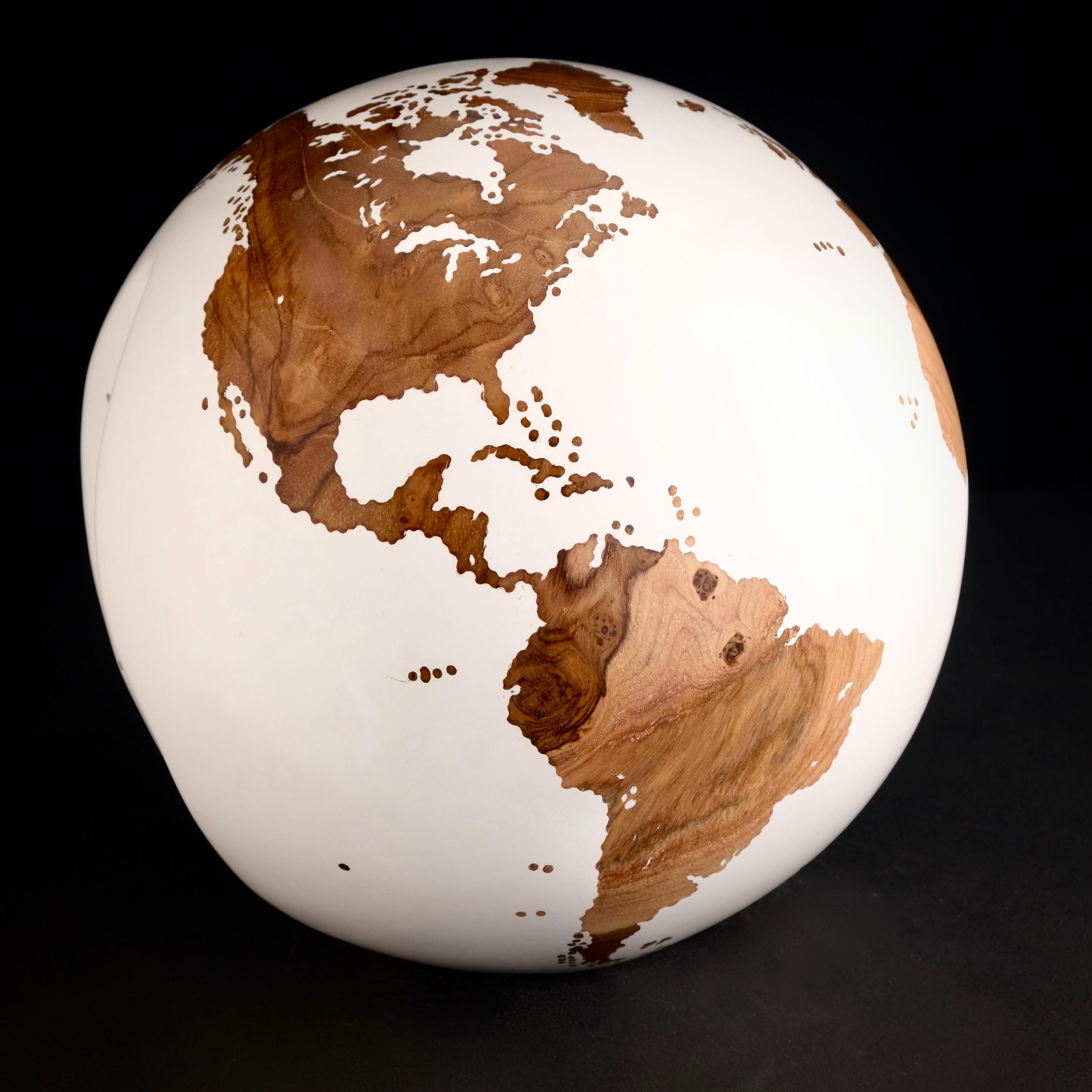 Teakwood and white lacquer make this beautiful turning globe a real stunning sculpture.
Made from a whole piece of wood the way the sculpture is shaped is defined by how the tree grew.
Sitting on a turning base the sculpture can spin silently