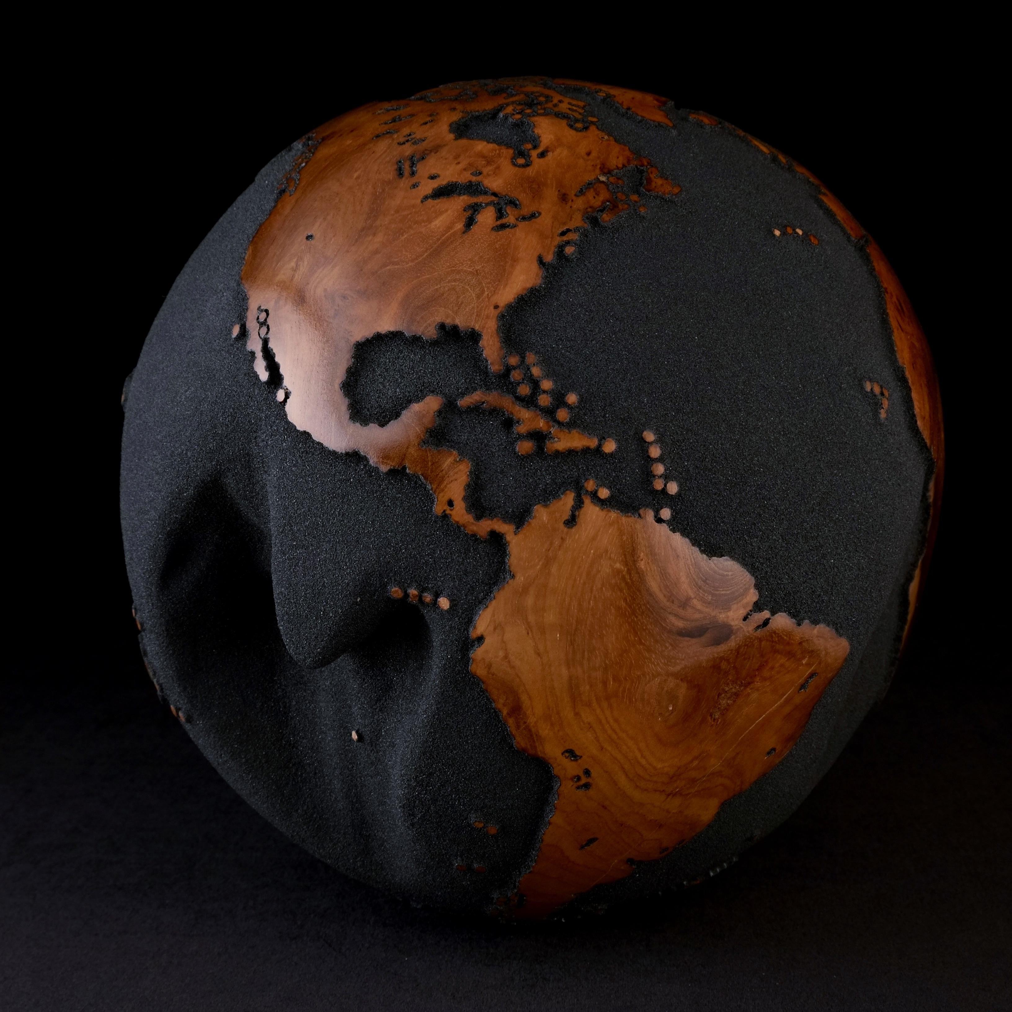 Teakwood and black lava sand make this beautiful turning globe a real stunning sculpture.
Made from a whole piece of wood the way the sculpture is shaped is defined by how the tree grew.
Sitting on a turning base the sculpture can spin silently