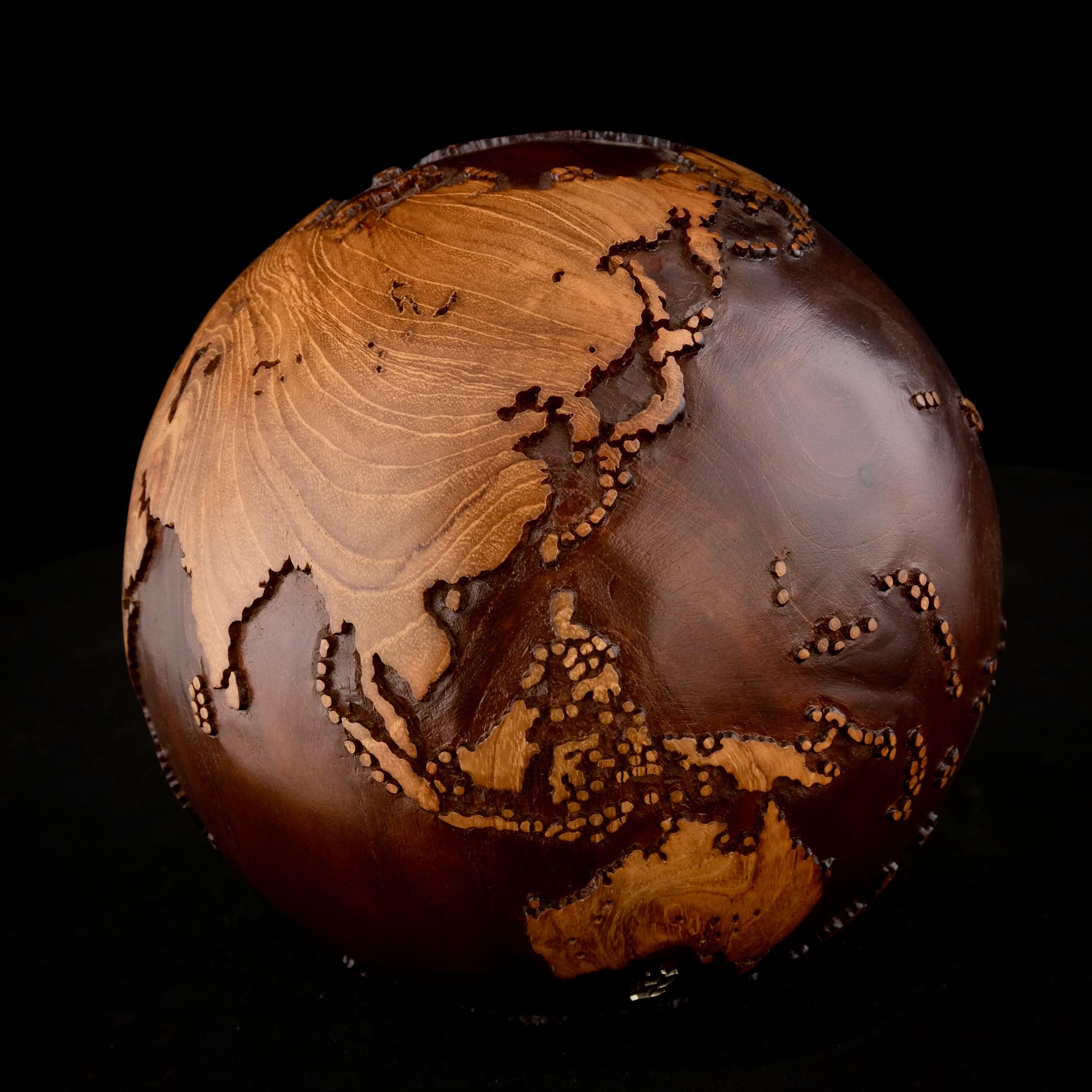 La teinture du noyer fait de ce magnifique globe tournant une véritable sculpture.
Réalisée à partir d'un morceau de bois entier, la sculpture est façonnée en fonction de la croissance de l'arbre.
Posée sur un socle tournant, la sculpture peut