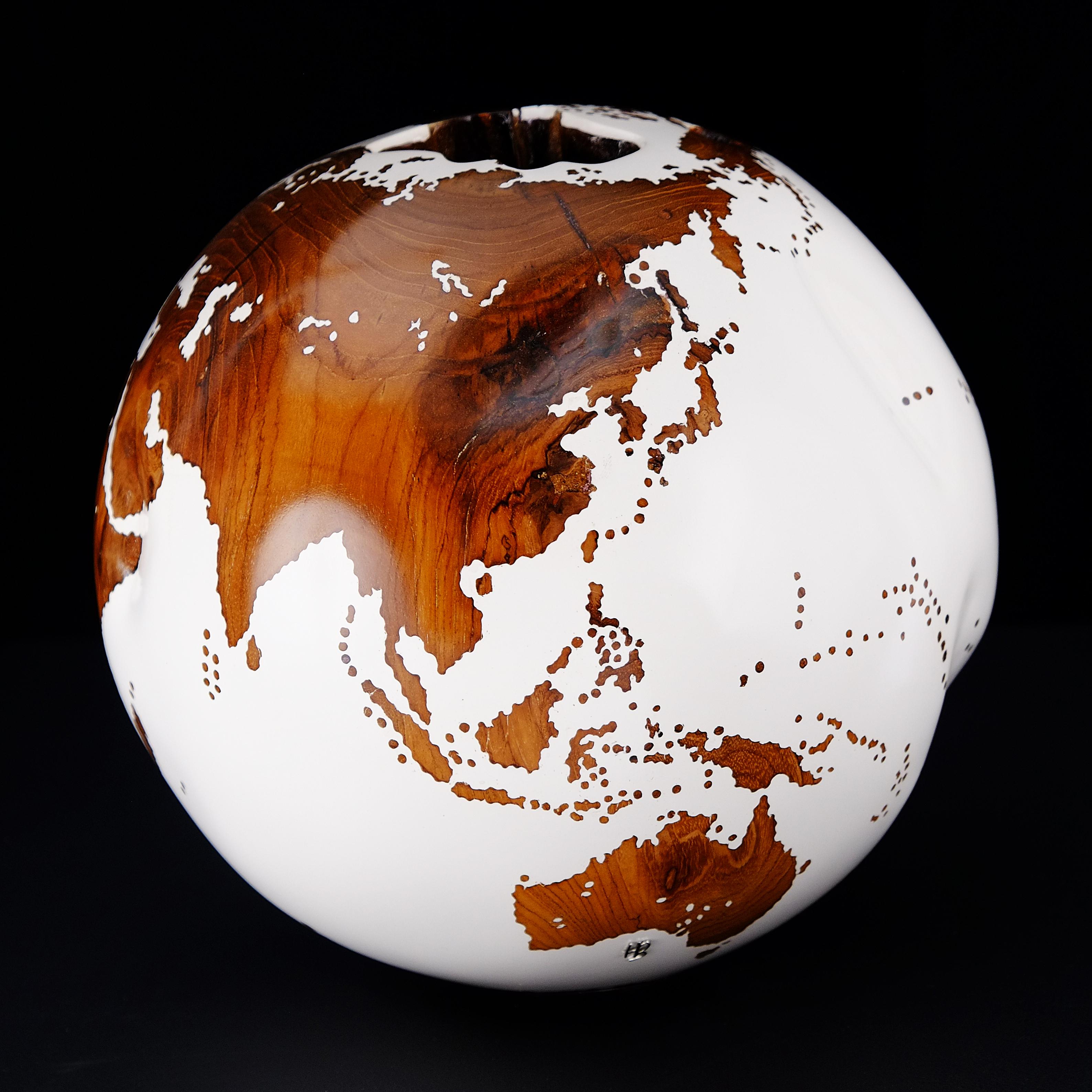Teakwood and white make this beautiful turning globe a real stunning sculpture.
Made from a whole piece of wood the way the sculpture is shaped is defined by how the tree grew.
Sitting on a turning base the sculpture can spin silently around, so
