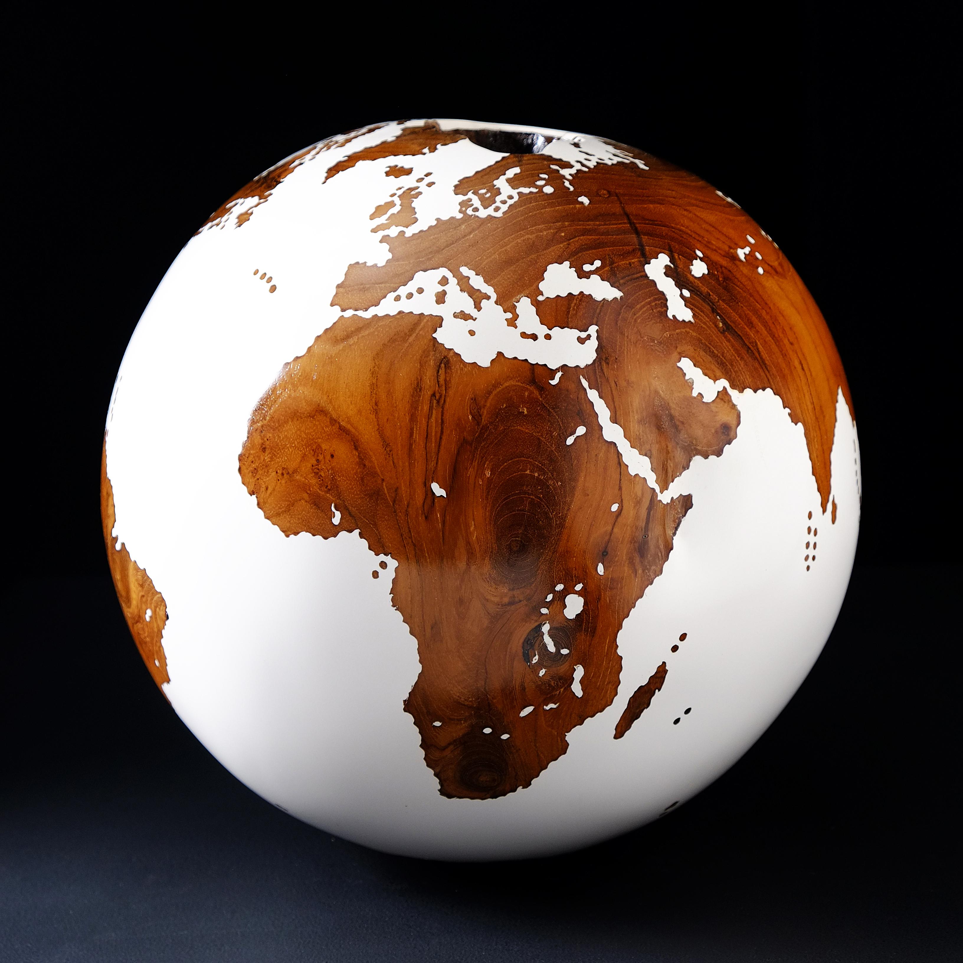 Teakwood and white make this beautiful turning globe a real stunning sculpture.
Made from a whole piece of wood the way the sculpture is shaped is defined by how the tree grew.
Sitting on a turning base the sculpture can spin silently around, so