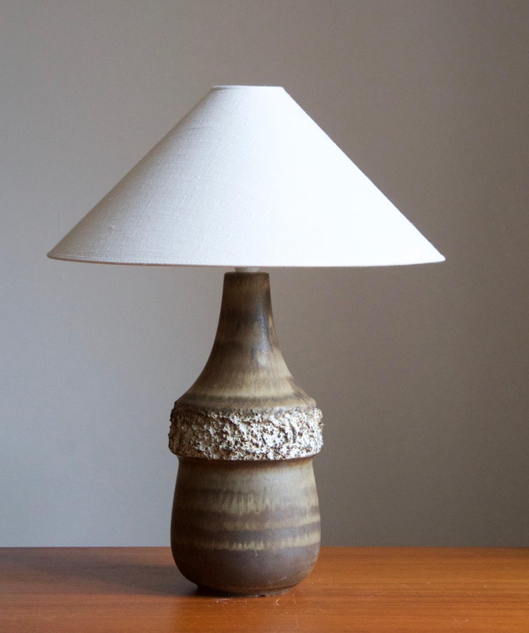 A sizable stoneware table lamp, executed by Bruno Karlsson at Ego Stengods Atelje. Stamped and initialed at bottom. 

Stated dimensions exclude lampshade. Height including socket. Sold without lampshade.

Glaze features a grey-brown color.

Other