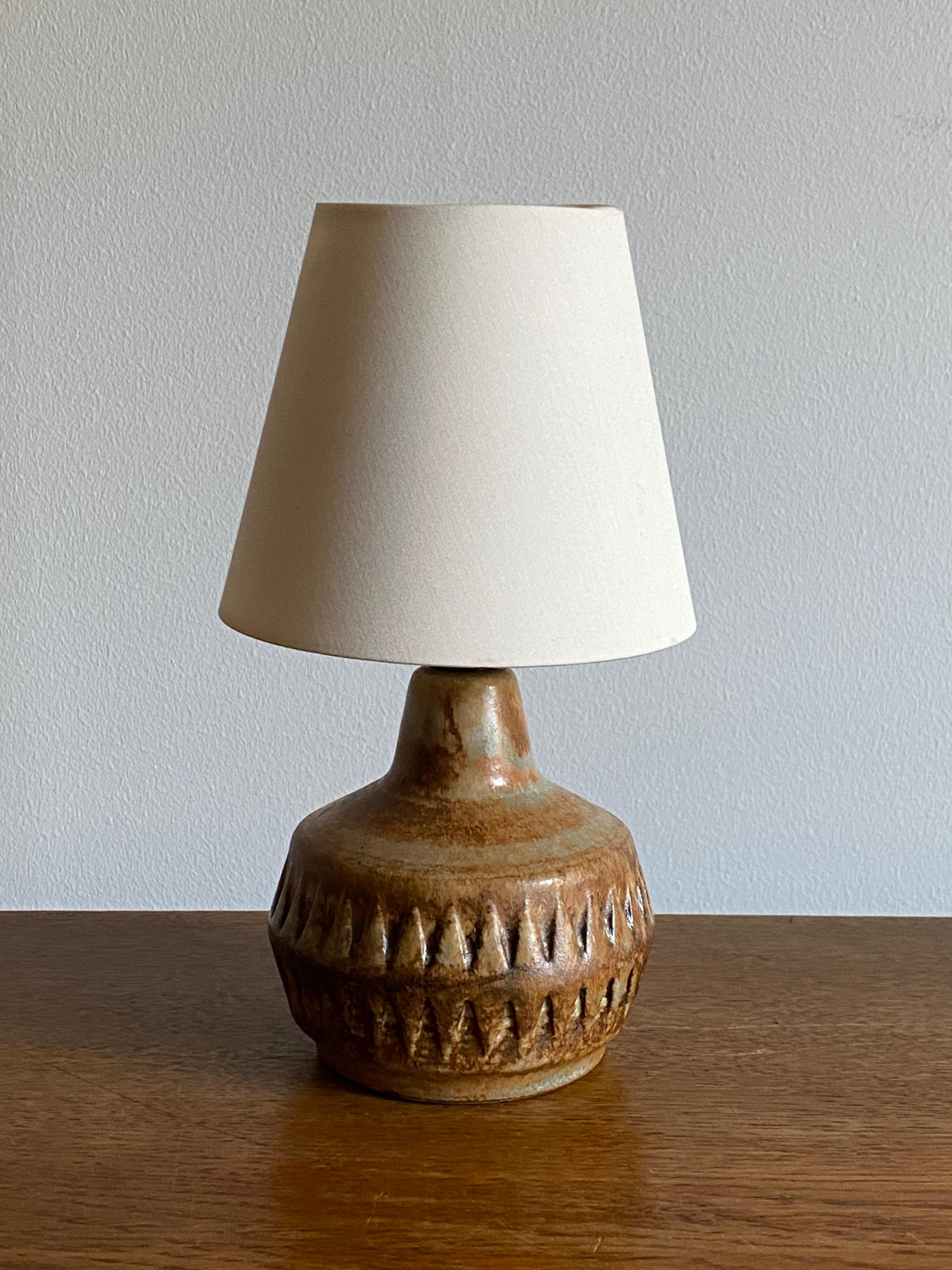 Une lampe de table en grès, exécutée par Bruno Karlsson dans une forme abstraite et une glaçure marron / jaune / beige très artistique. Dans son studio, appelé 