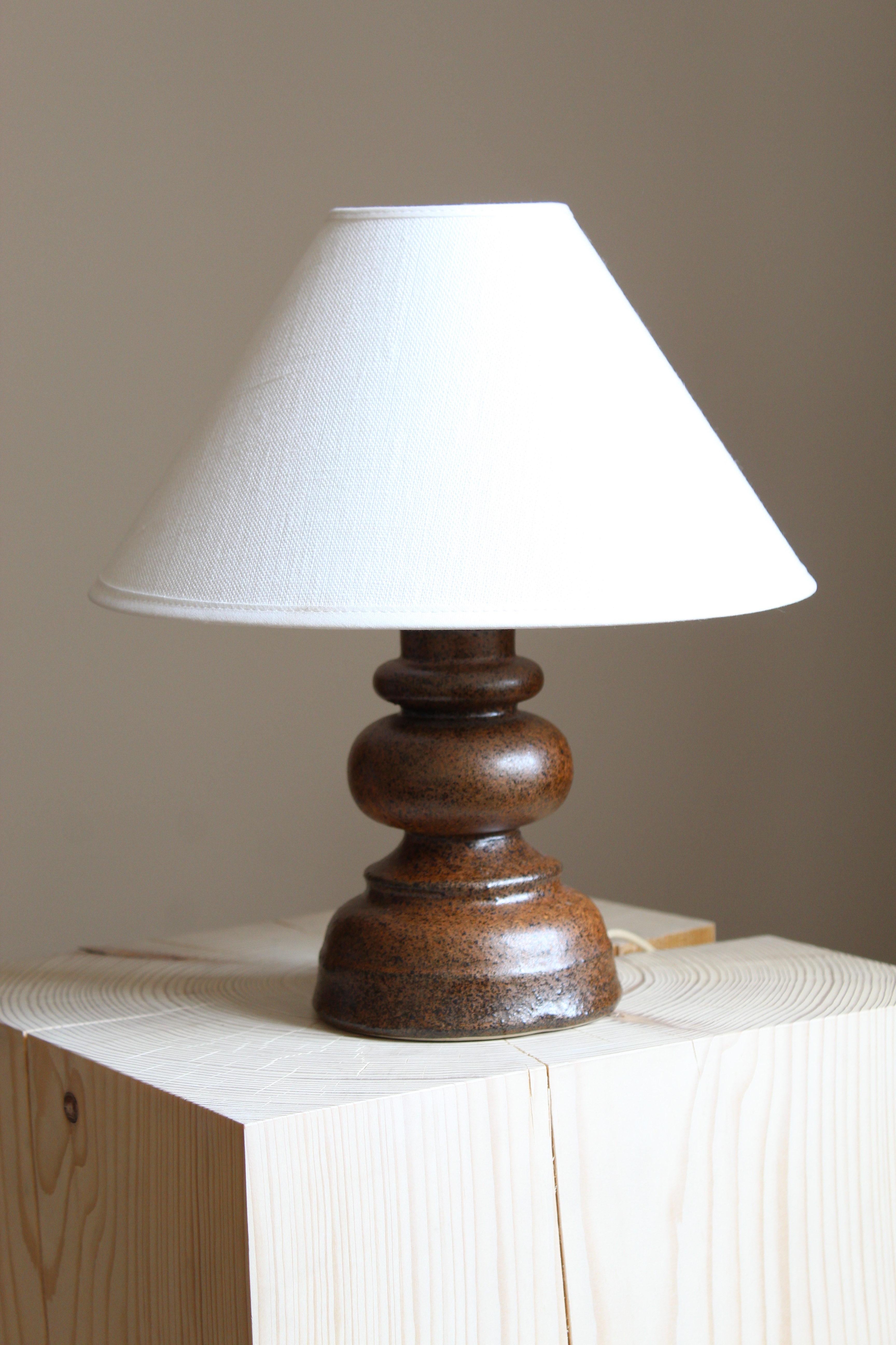 Lampe de table en grès, exécutée par Bruno Karlsson dans une forme abstraite et une glaçure brune très artistique. Dans son Studio, appelé 