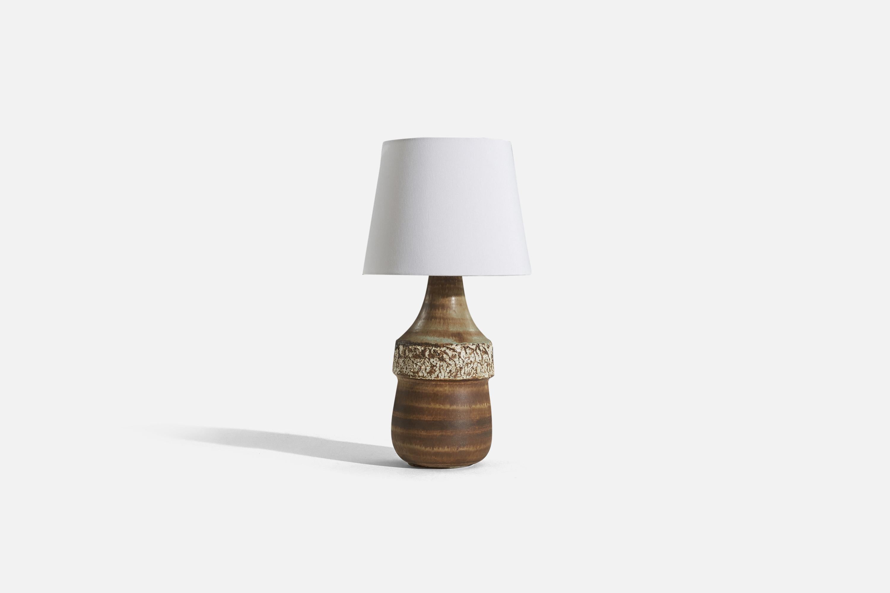 A brown-glazed stoneware table lamp designed by Bruno Karlsson and produced by Ego Stengods, Sweden, c. 1960s.

Sold without lampshade. 
Dimensions of Lamp (inches) : 15.375 x 5.875 x 5.875 (H x W x D)
Dimensions of Shade (inches) : 7.5 x 10 x 8 (T