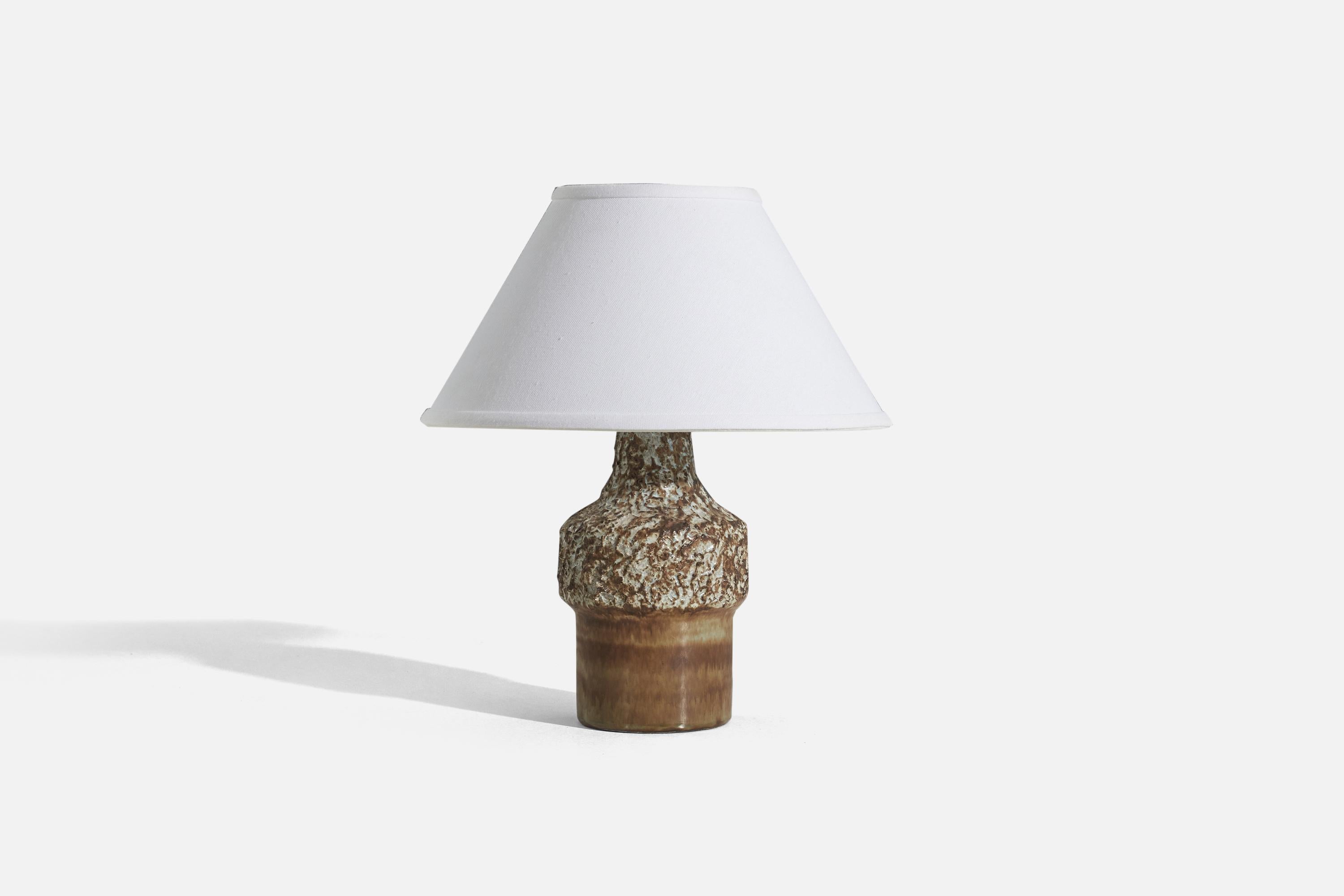 A brown-glazed stoneware table lamp designed by Bruno Karlsson and produced by Ego Stengods, Sweden, c. 1960s.

Sold without lampshade. 
Dimensions of Lamp (inches) : 10.8125 x 5.0625 x 5.0625 (H x W x D)
Dimensions of Shade (inches) : 5 x 12.25 x