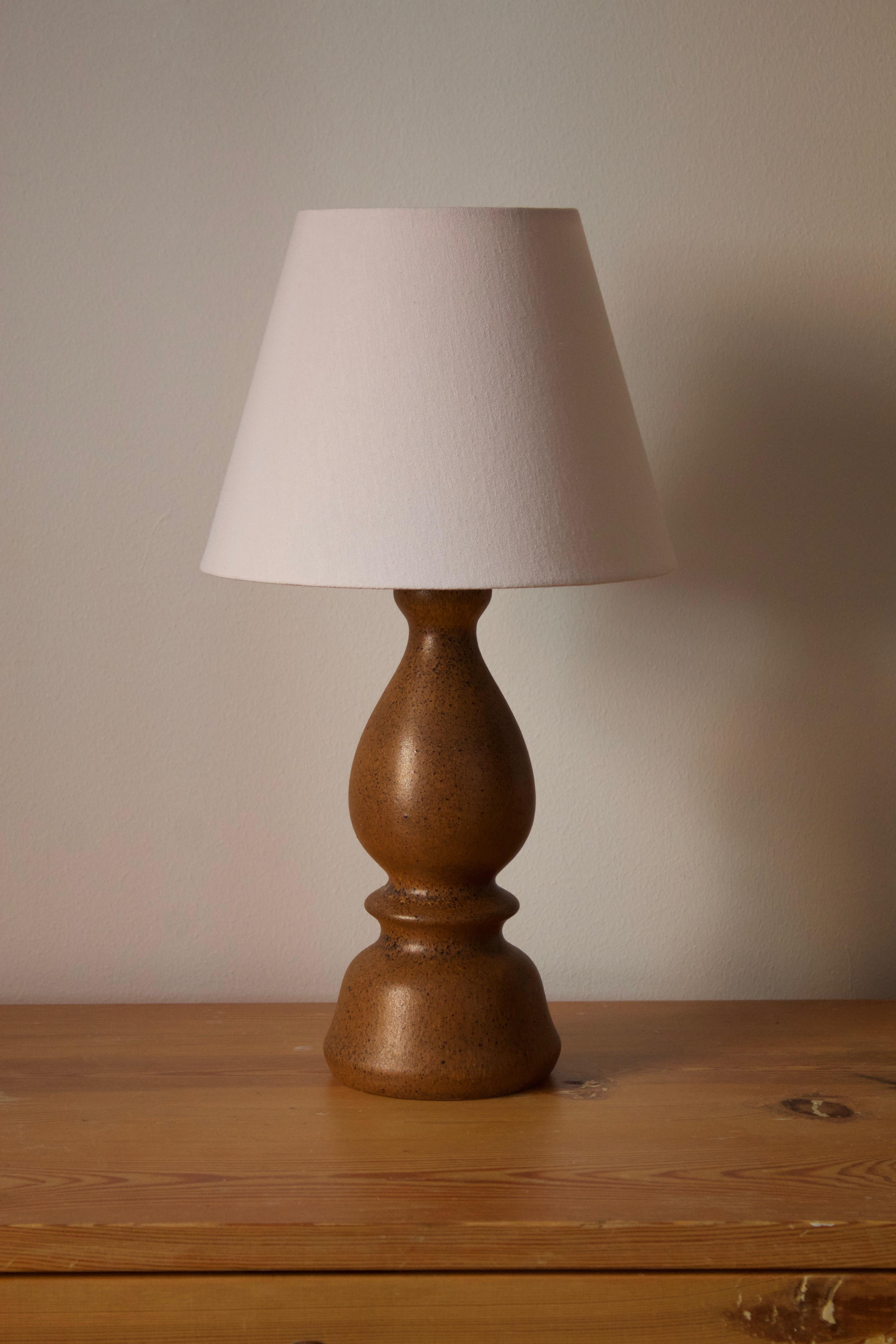 Une lampe de table en grès, exécutée par Bruno Karlsson dans une forme abstraite et une glaçure brune très artistique. Dans son studio, appelé 