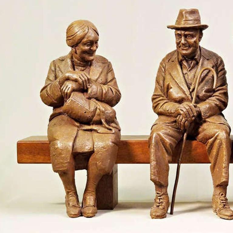 Scultura di 3 figure sedute su una panchina