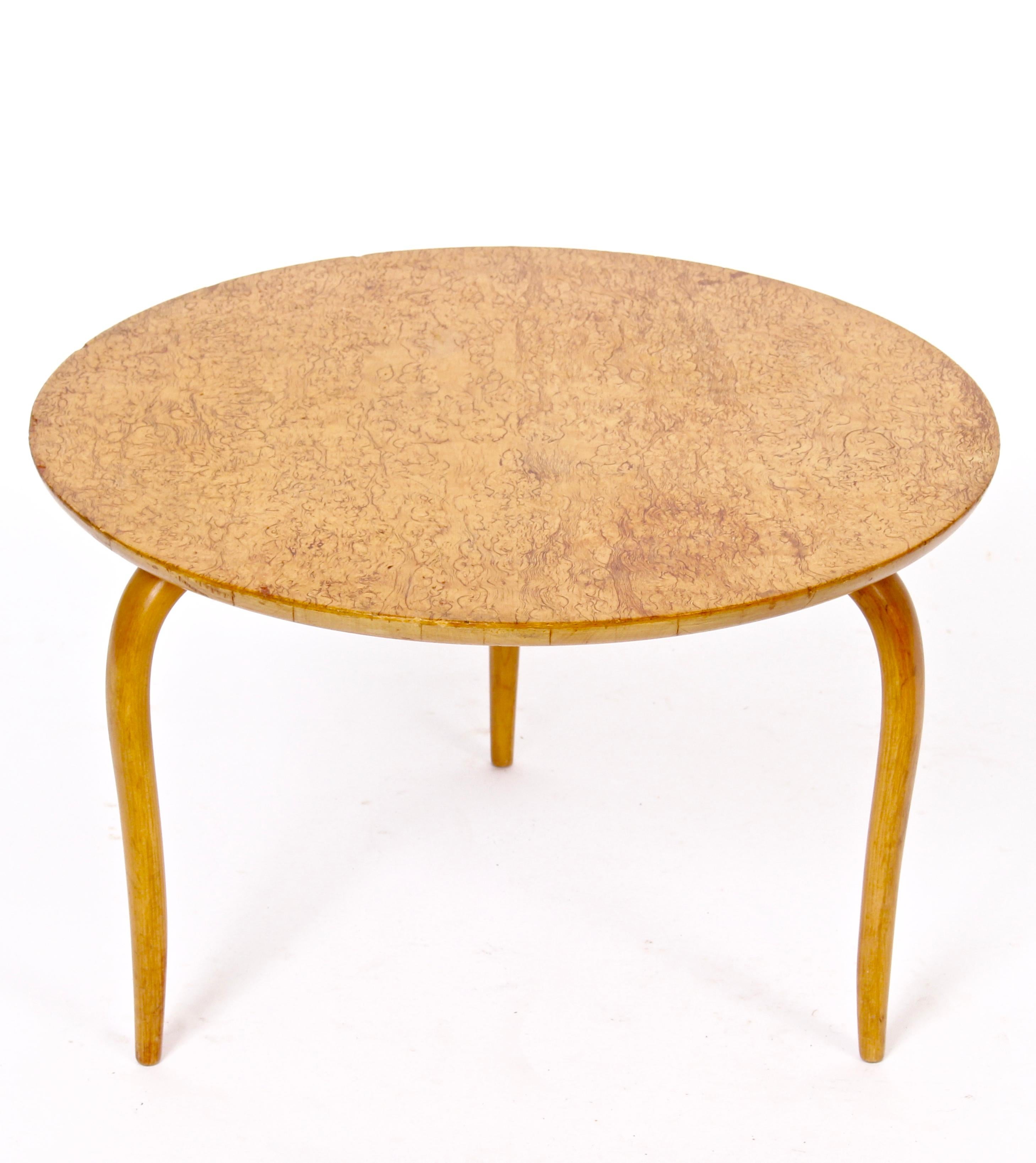 Swedish modern Bruno Mathsson for Karl Mathsson Karelian birch Annika lower coffee table. Featuring a round Karelian Birch surface finished with rounded edges, curved tapered bent plywood legs. Stamped Bruno Mathsson, Firma Karl Matthson, 1960, made