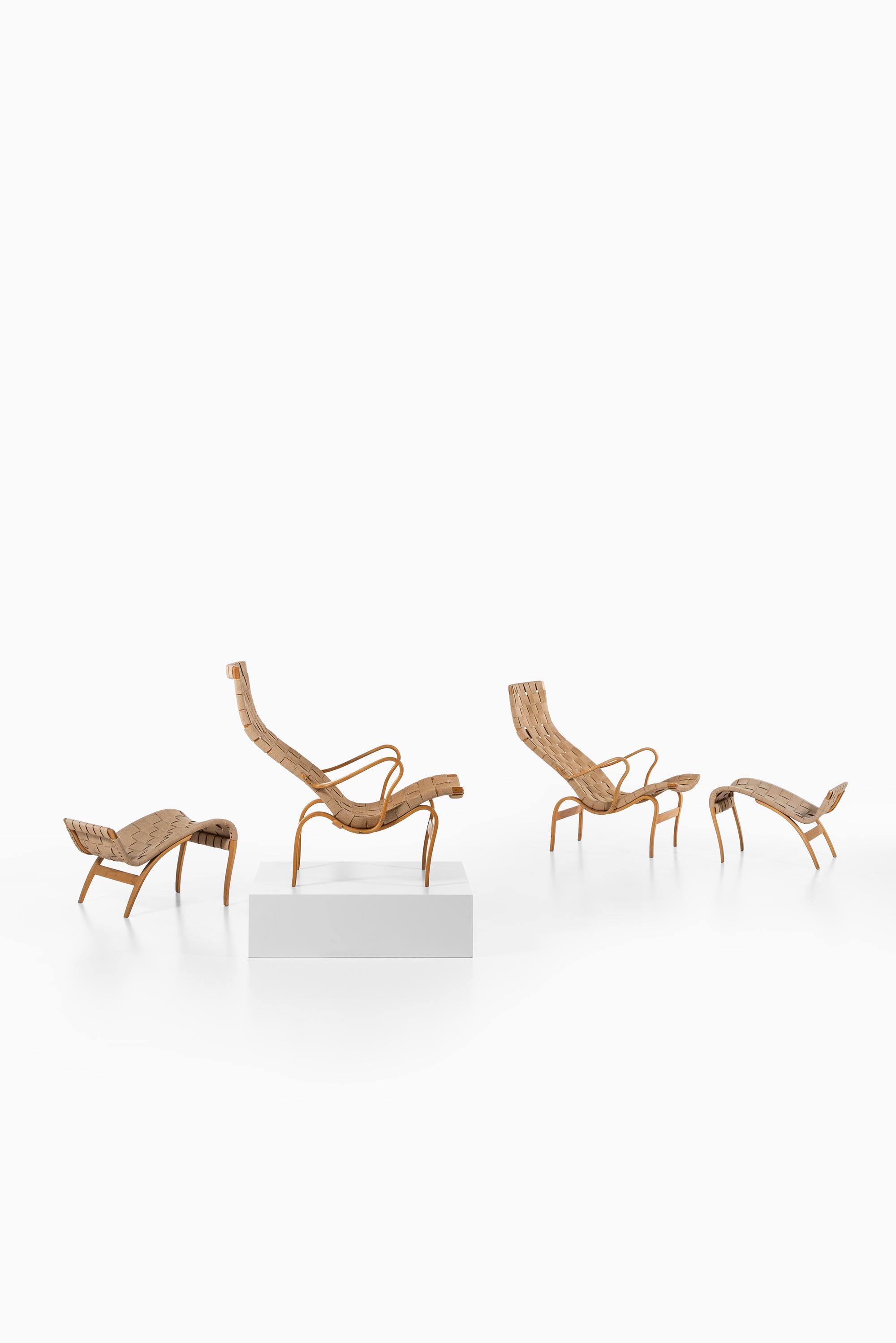 A pair of easy chairs with stools model Pernilla designed by Bruno Mathsson. Produced by Karl Mathsson AB in Värnamo, Sweden.