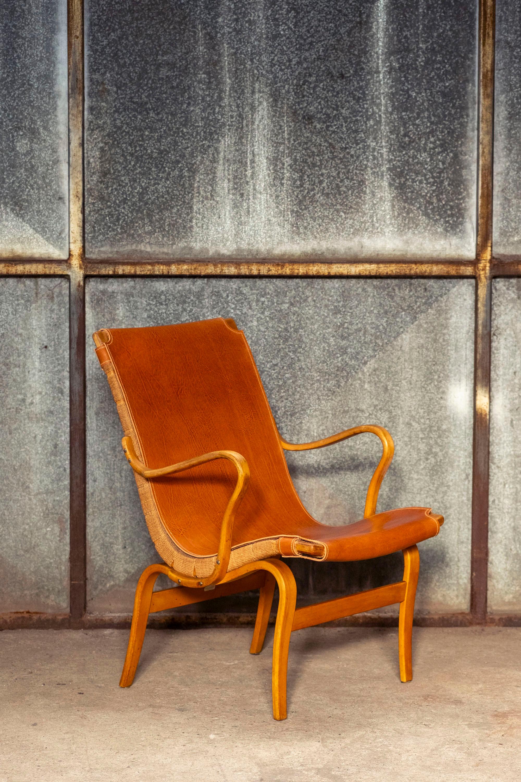 Early lounge chair, model Eva by Bruno Mathsson with full grain leather upholstery.
Produced in the 1960s by Karl Mathsson in Sweden.
Functional, elegant and comfortable armchair.
Maker's mark on the back and Illums Bolighus label from the Danish