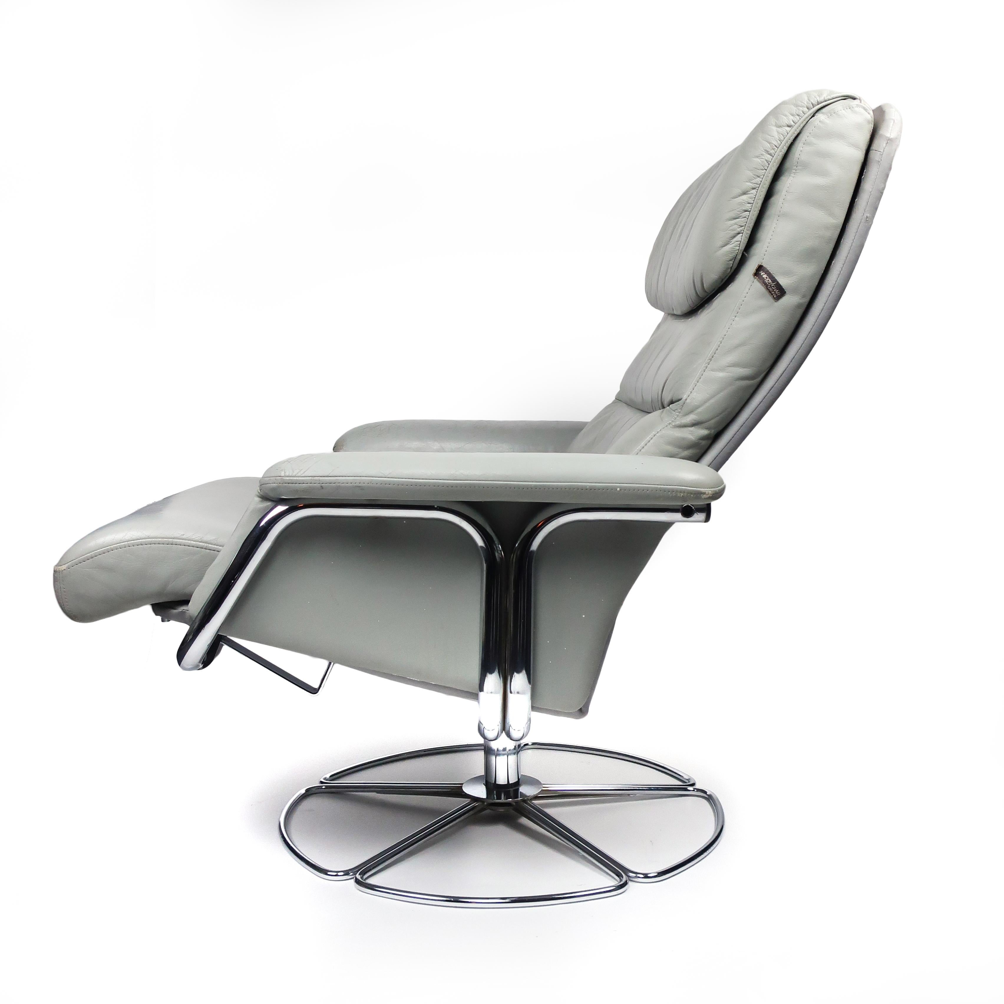 A vintage 1970s gray leather and chrome lounge chair and foot stool by Bruno Mathsson for DUX. With a lovely silhouette, this chair swivels and lays almost flat when reclined, making it incredibly comfortable. Labeled on side of the chair’s back