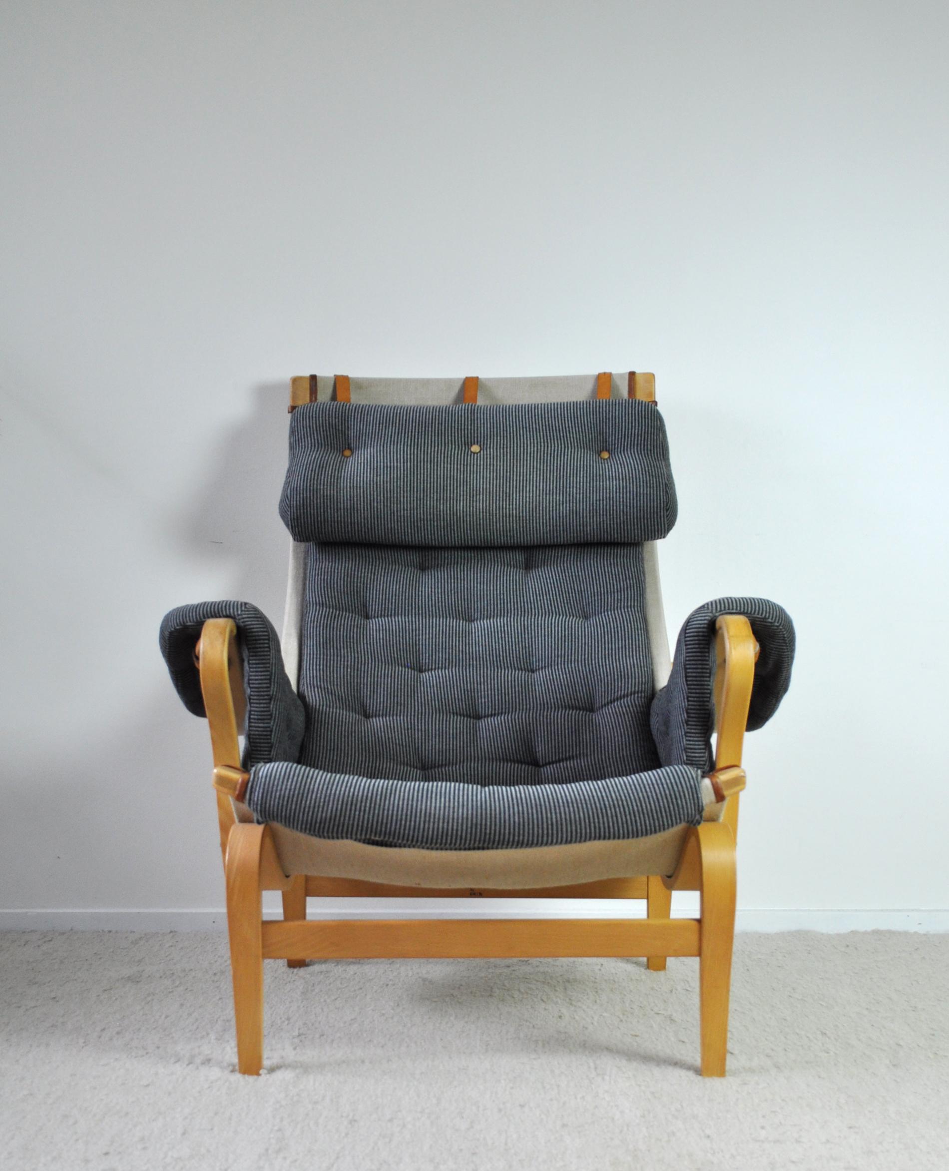 Comfortable Pernilla armchair designed by Bruno Mathsson. The first version was designed in 1944. This is an improved version designed for DUX in 1969. It comes with frame of moulded beech stretched with canvas and original fabric in a good vintage
