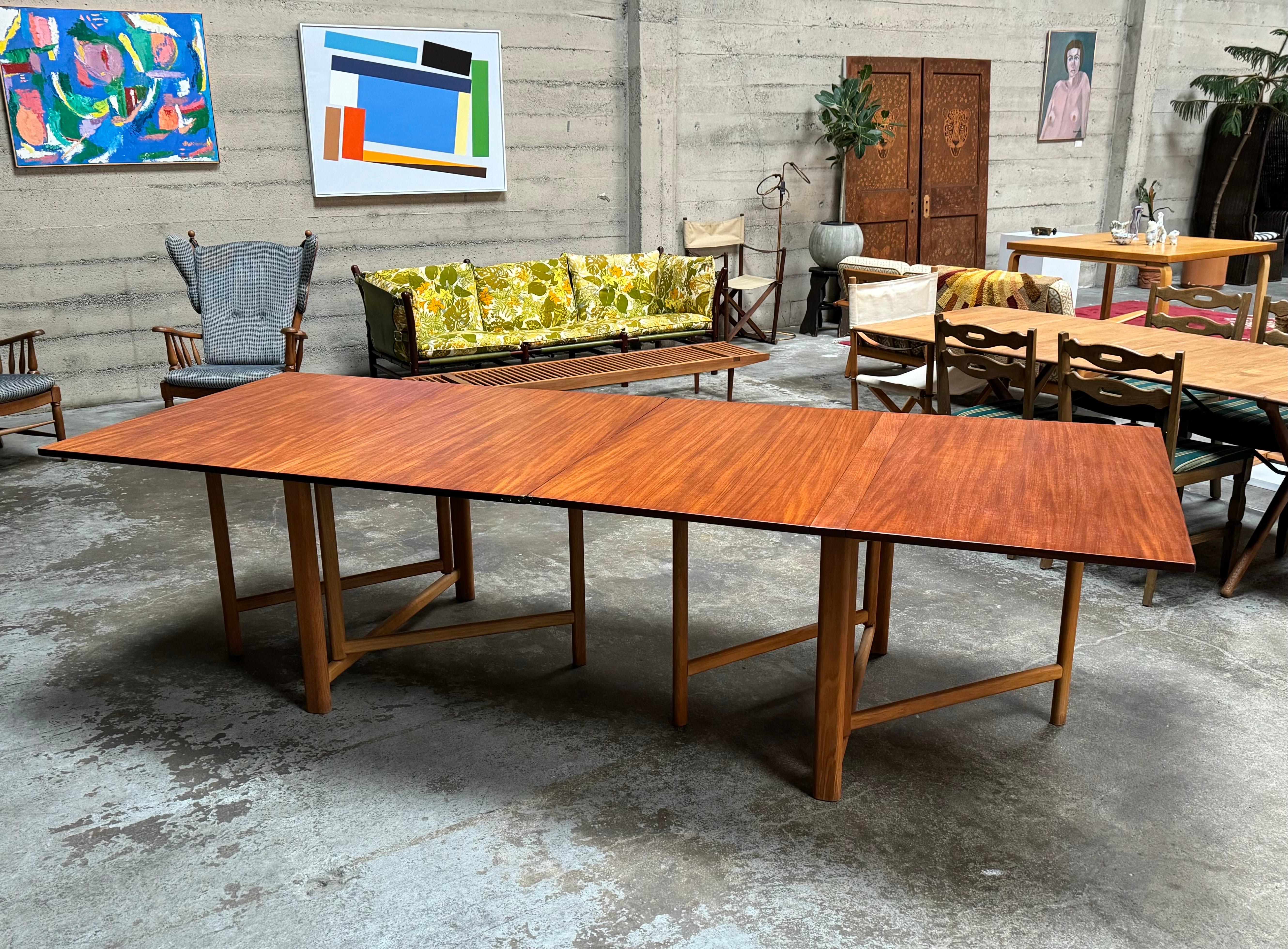 Bruno Mathsson Maria style dining table in teak and oak by Hafnia of Denmark, circa 1950s. This very functional design expands from 9” to 9’ 2” and can seat 12. Constructed with high quality materials with beautiful graining to the teak top all