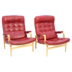 Bruno Mathsson, pair of Ingrid lounge chairs in maroon leather, DUX, 1969