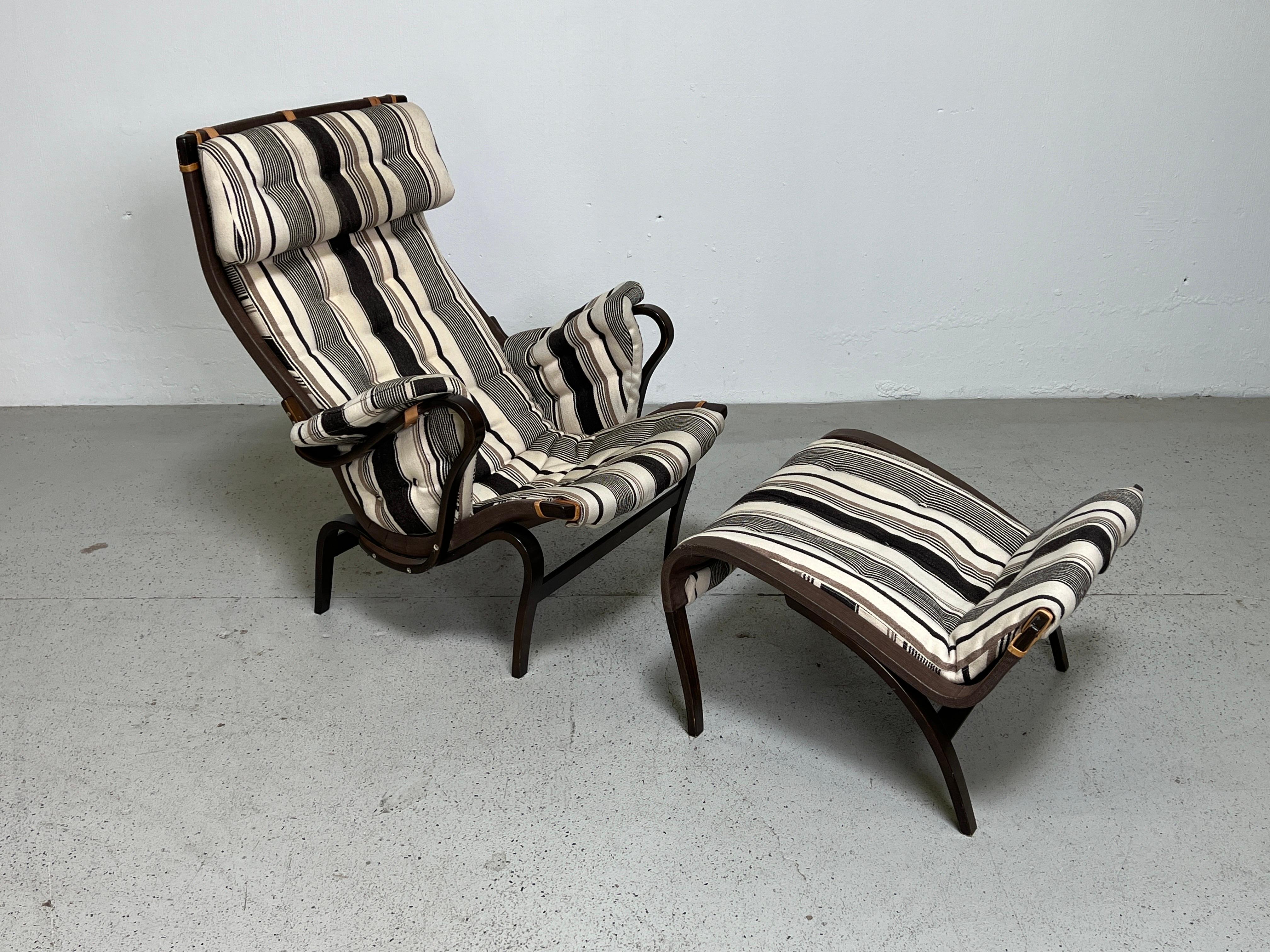 A Pernilla lounge chair and ottoman designed by Bruno Mathsson in original fabric.  
