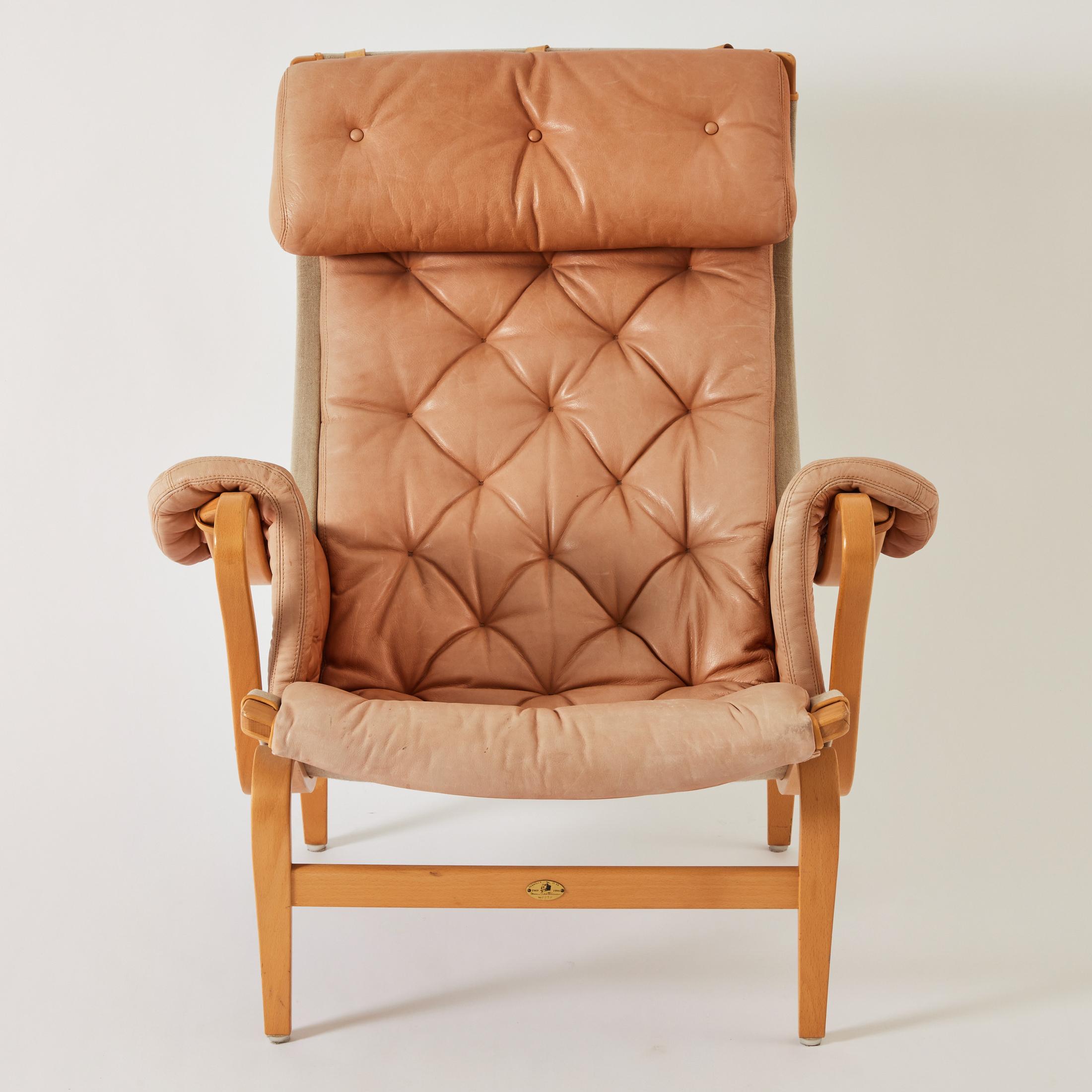 Bruno Mathsson leather Pernilla 69 lounge chair. This particular model was made as part of the 25 year anniversary edition in 1994. The leather has a lovely tonal color and the condition is very good. The curved frame is beech wood and the chair
