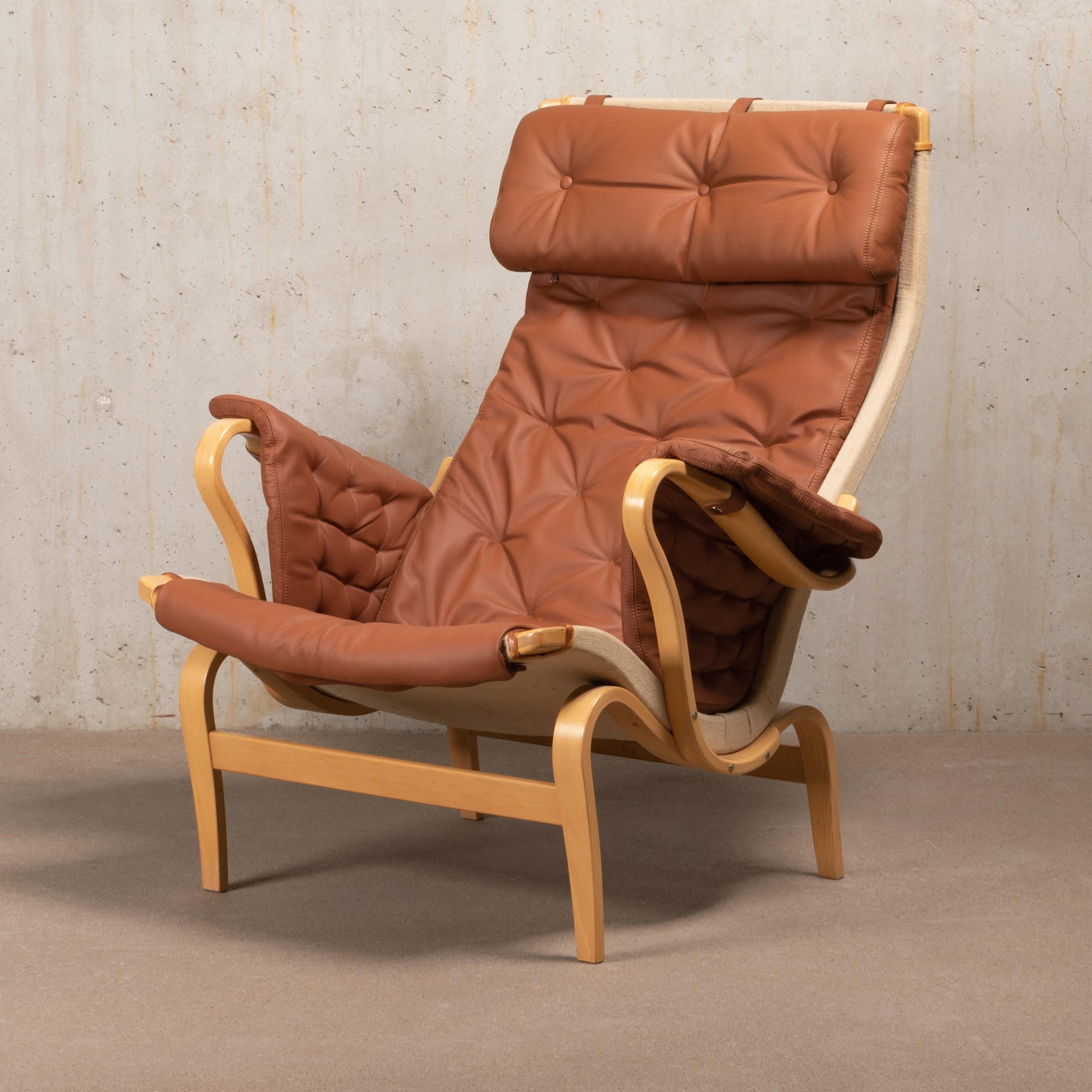 Comfortable easy lounge chair with ottoman designed by Bruno Mathsson in 1944 and manufactured by Dux, Sweden. Bended beech wood frame stretched with canvas and reupholstered with light brown coloured leather in excellent condition. Both chair and