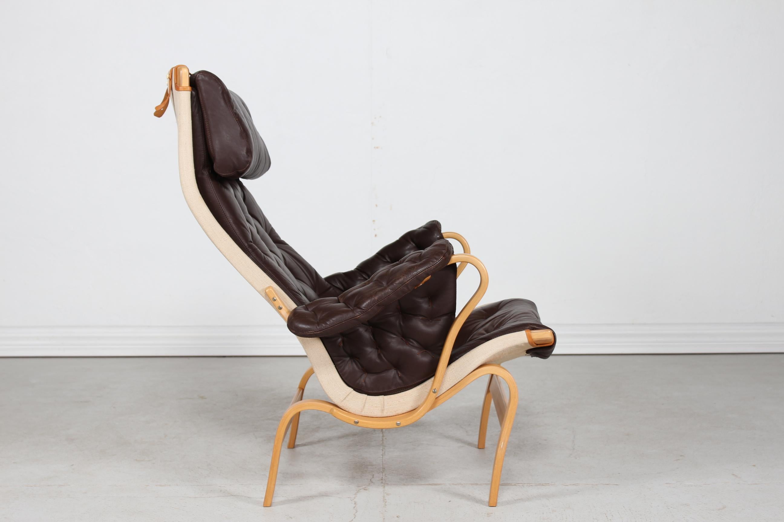 Scandinavian modern easy chair/ lounge chair model Pernilla manufactured by Dux of Sweden. Designed by architect and designer Bruno Mathsson in 1944.
The frame is made of steam bend beech with lacquer and the cushions are upholstered with mocha