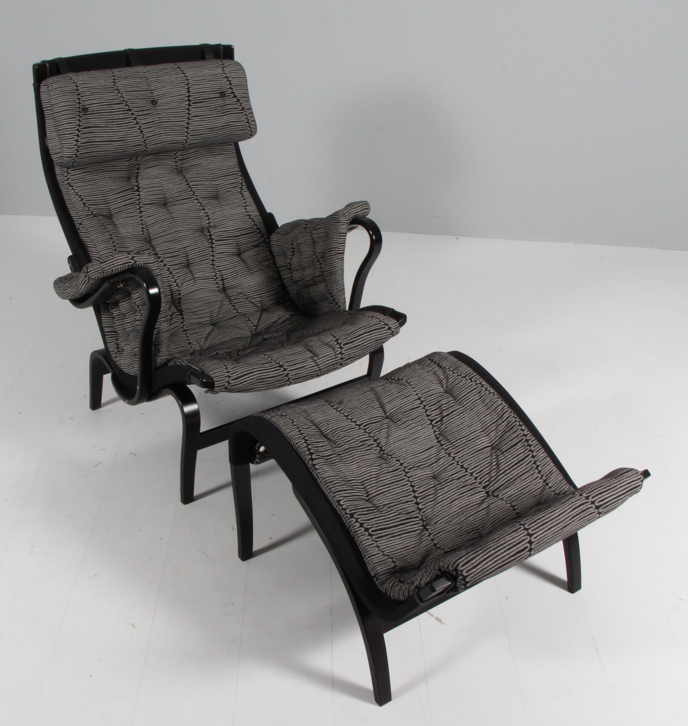 Bruno Mathsson Pernilla lounge chair with ottoman, original upholstery in fabric.

Frame in black lacquered beech.

Made by DUX.

This is a special editon celebrating Bruno Mathsson 100th birthday