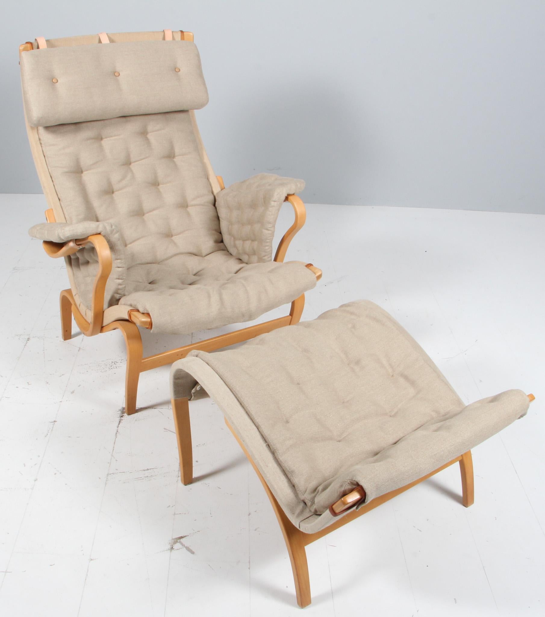 Bruno Mathsson Pernilla lounge chair with ottoman, new original canvas upholstery.

Frame in lacquered beech.

Made by DUX.

