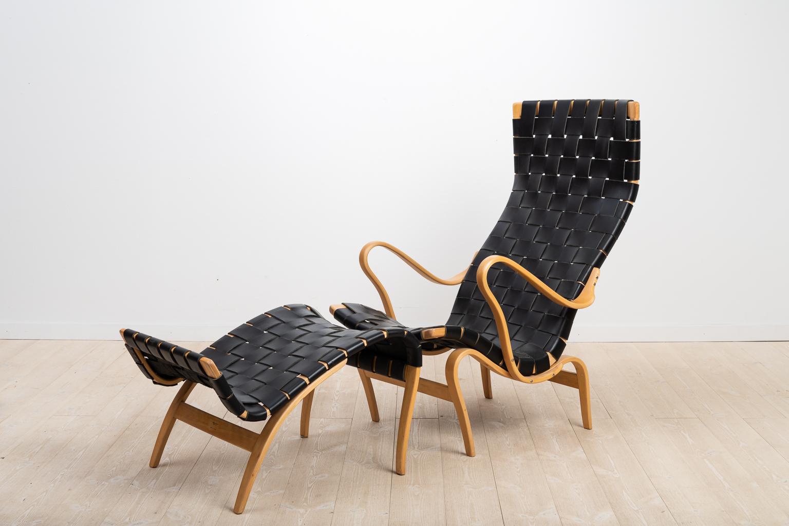 Bruno Matsson lounge chair Pernilla 2 and ottoman Pernilla 69. Designed by Matsson 1944. Both pieces are marked with authenticity stamps. The chair and ottoman are newly renovated and the black leather straps are new.