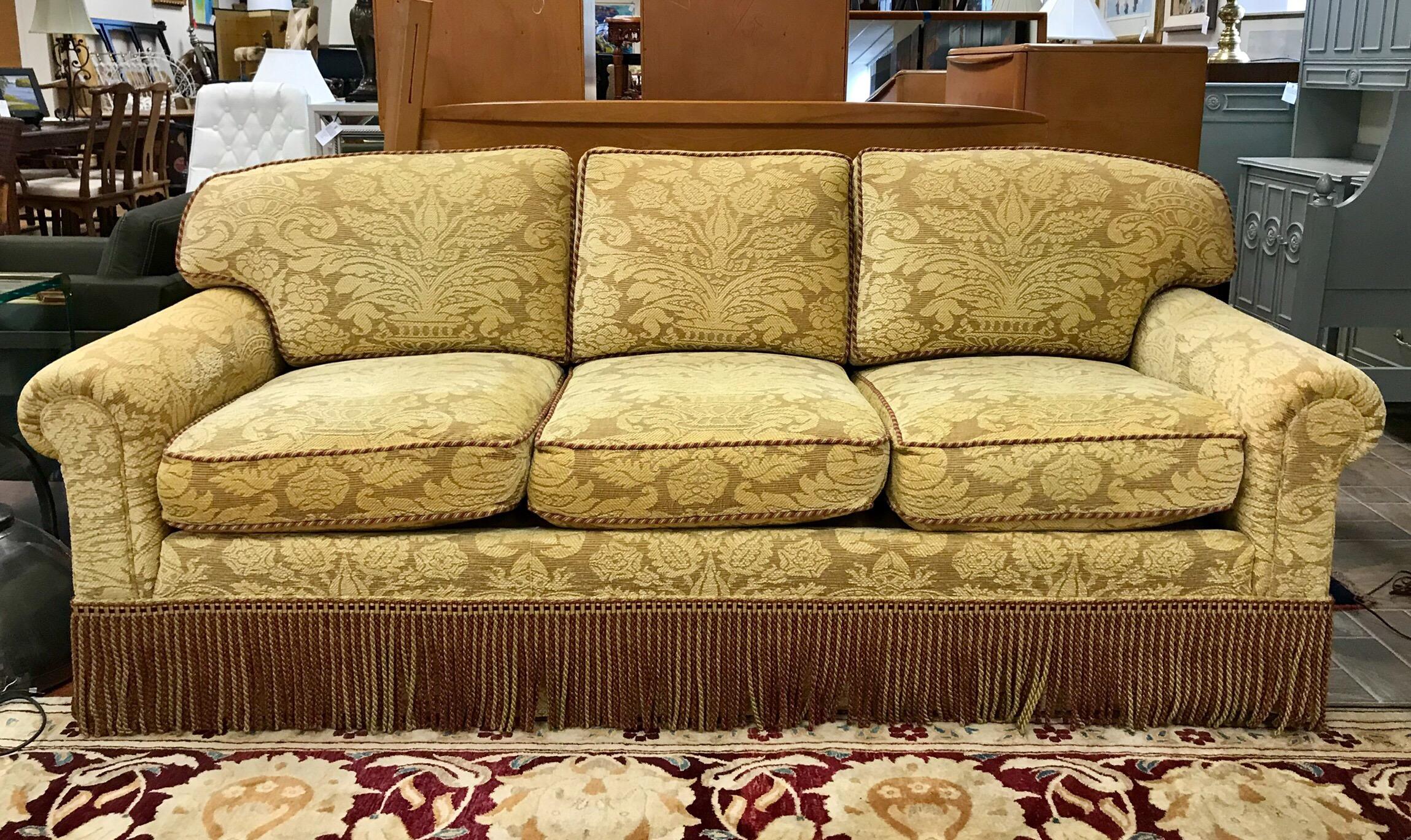 Custom made designer sofa, circa early 21st century upholstered in luxurious damask Brunschwig and Fils fabric and finished with coordinating buillion fringe. Features eight way hand tied construction and down-filled cushions. Both comfy and chic.