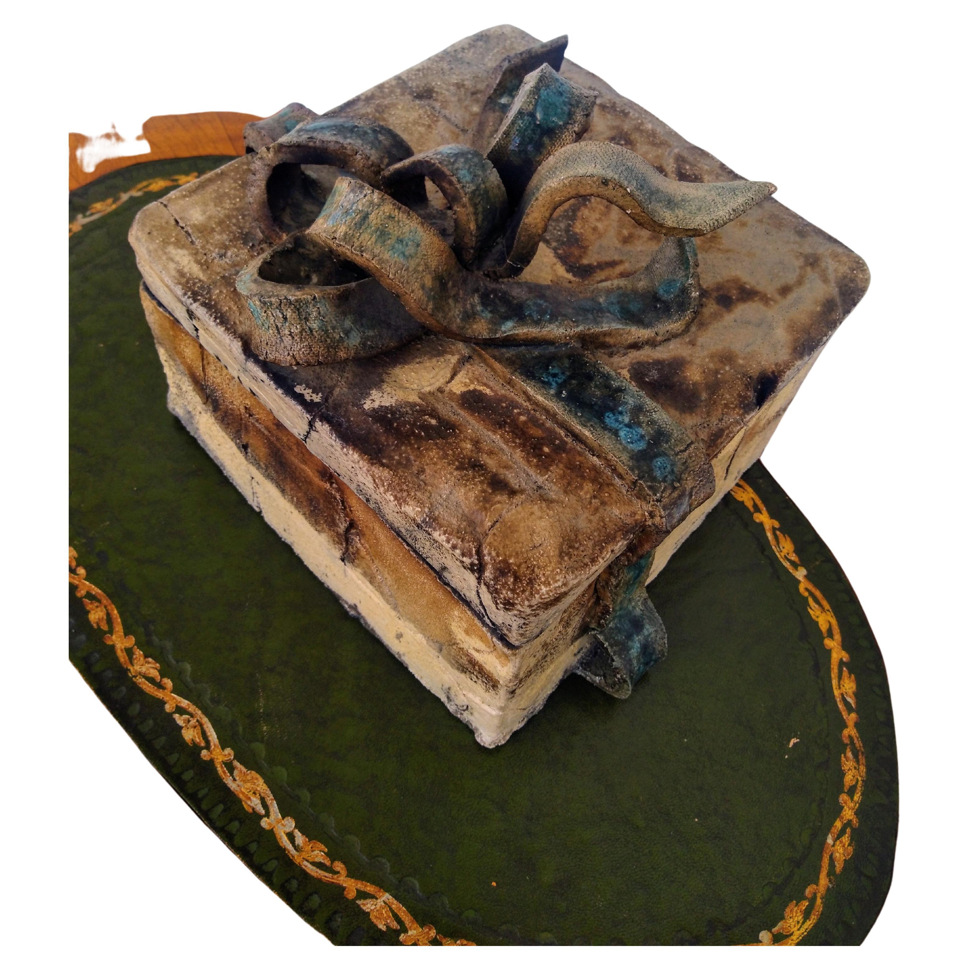Questa scatola regalo è stata realizzata dall'artista Bruny Graves. È realizzato in stile Raku. Il raku è un processo a bassa cottura che produce risultati unici e imprevedibili. La scatola è piena di rotoli Haiku che contengono frasi poetiche.