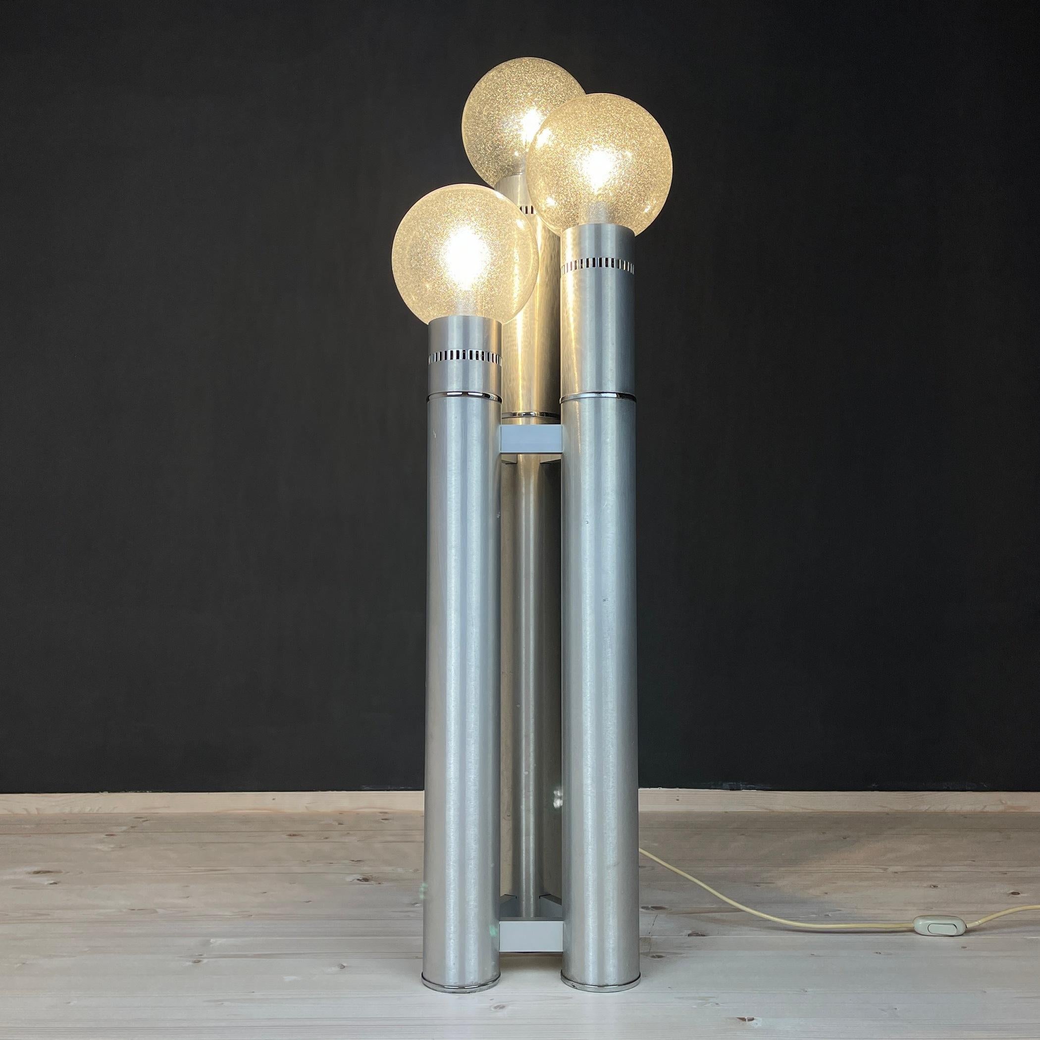 Excellent brushed aluminum tube floor lamp from Italy. 1970s, Reggiani/Sciolari period. Three tubes with varying heights and bubble glass ball shades. The lamp is still in excellent working order. There are undoubtedly some stains or other evidence