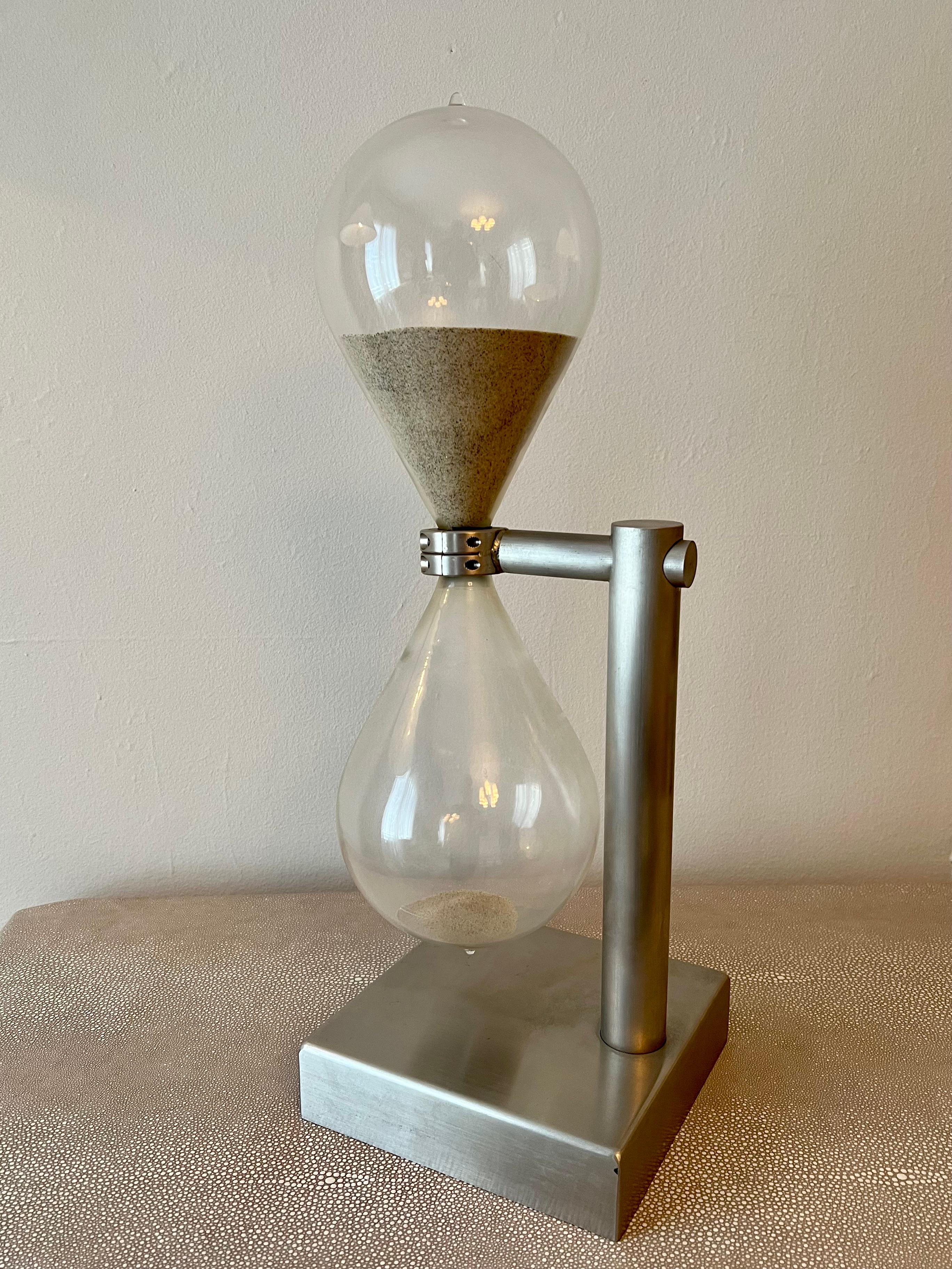 Modern industrial brushed aluminum hourglass - in the style of Bauhaus industrial - German, Berlin.

An interesting contrast of blown glass and heavy industrial material gives this piece a stern and focal point of character.