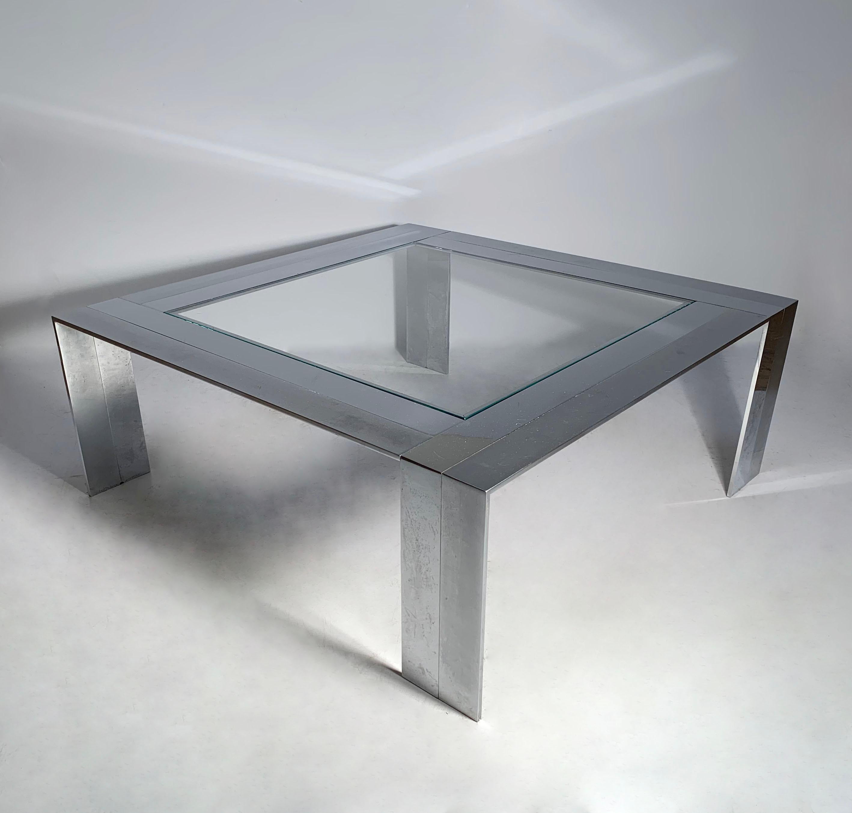 Brushed and polished stainless steel  glass coffee table attributed to DIA. The brushed against the polished finish creates a attractive graphic effect in 3 dimensional space. This is a solid and heavy constructed form. All welded from the