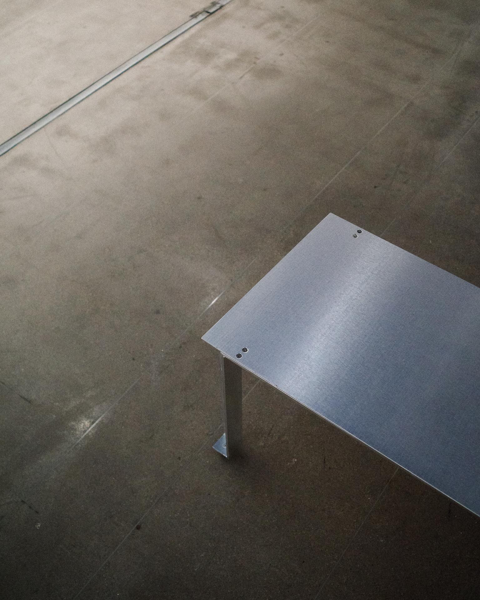 Le banc CANTO de Luiz Solano prolonge la logique de la série dans un siège généreux et linéaire. Composé entièrement d'aluminium brossé et anodisé - profilé d'angle et tôle de même épaisseur - il met l'accent sur l'absence autant que sur la forme.