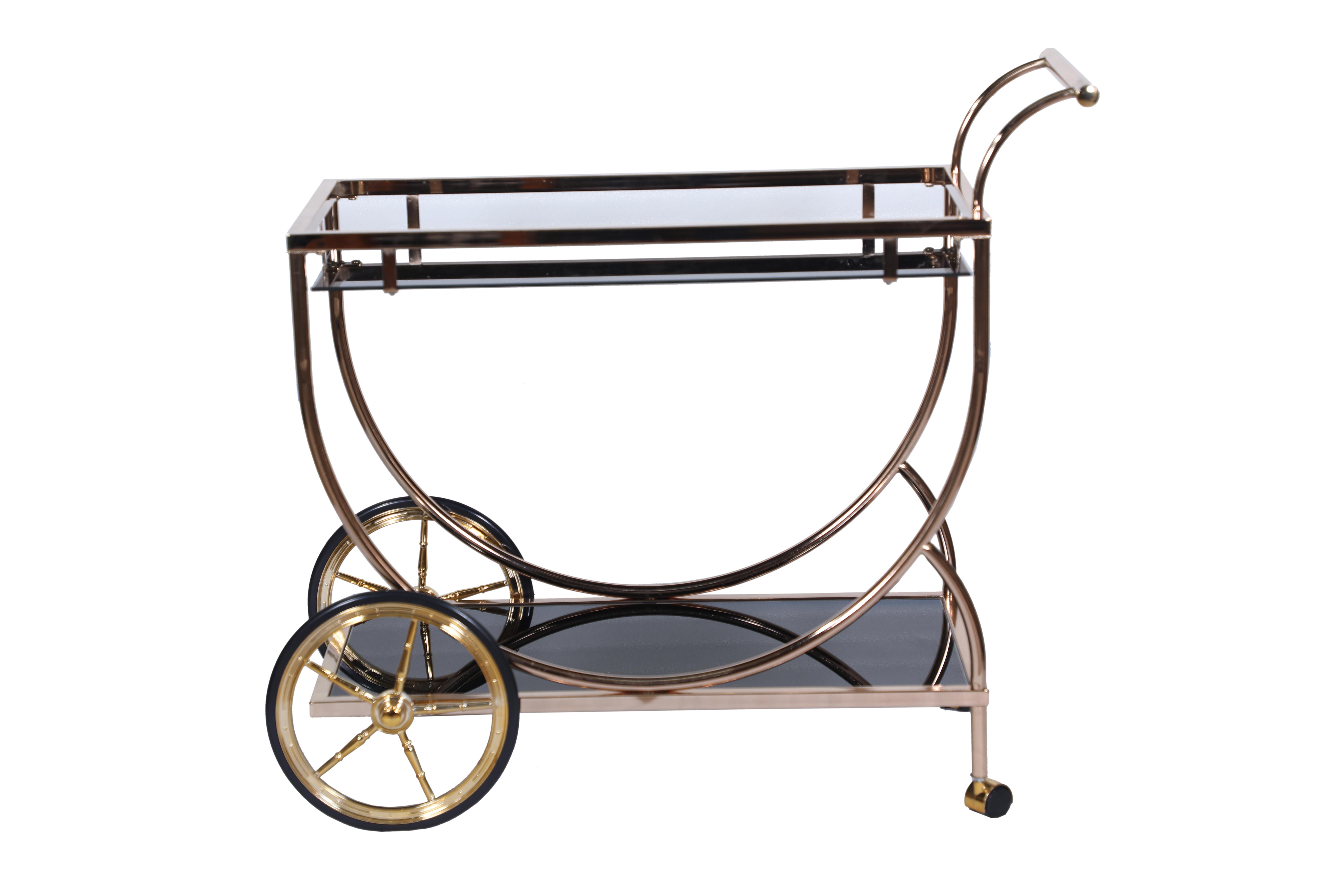 A brushed brass trolley or bar cart with glass shelves.  Handle on once side, larger wheels on the other and swivel wheels on the handle side.  1980's.

The Lockhart Collection is a personally curated gallery of antiques and fine jewelry, owned and