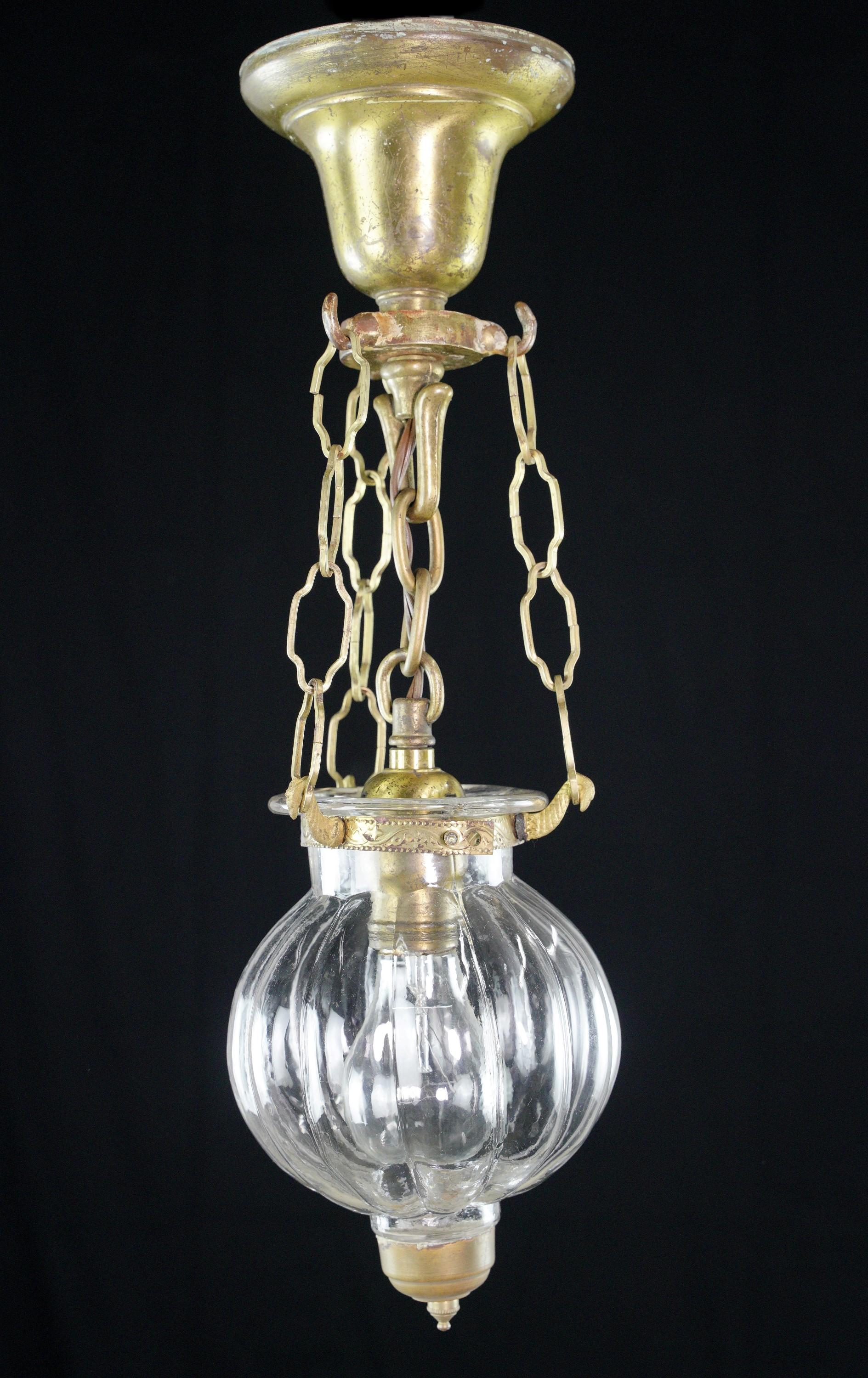 The vintage onion shaped glass bell jar pendant light is a nostalgic lighting fixture that combines the charm of brushed brass, steel construction, and a clear glass ball, creating a captivating vintage ambiance in any space. Cleaned and restored.