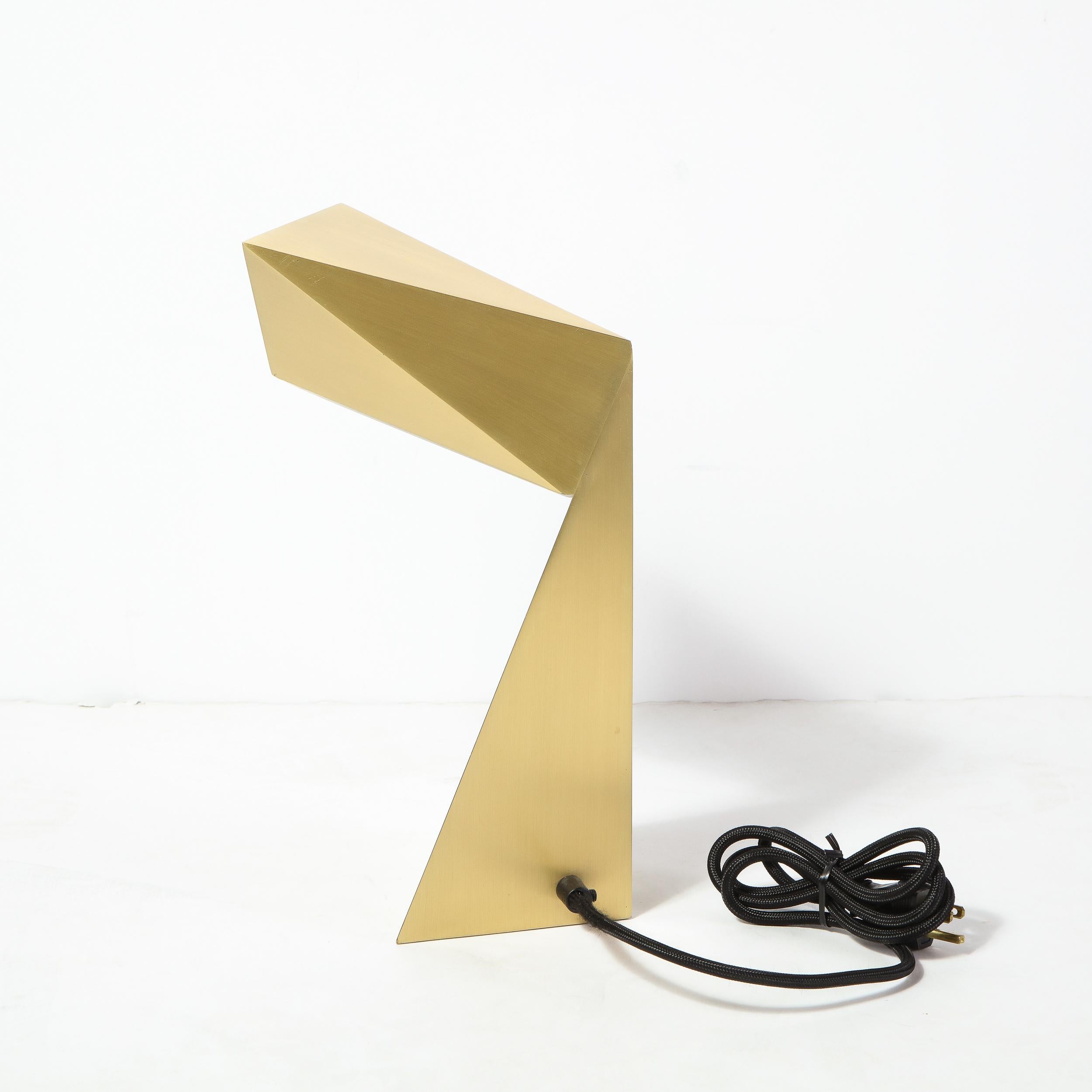 This stunning modernist Origami t desk /Table lamp was by Pouenat in the United States. It features a faceted cantilevered body in brushed brass, whose forward looking design recalls the influence of space age designs and Italian futurism. With its