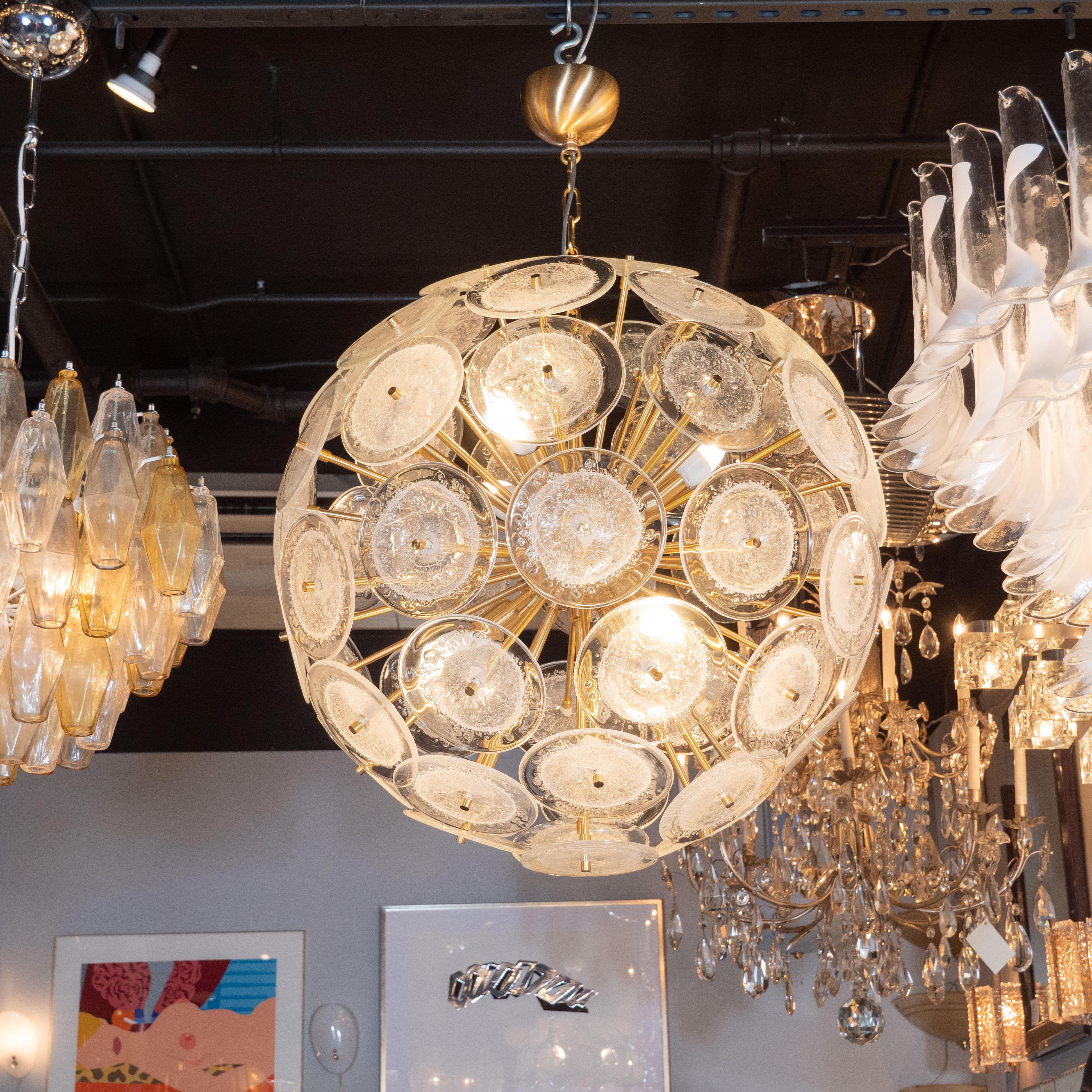 This dramatic and graphic sputnik was realized in Murano, Italy- the islands off the coast of Venice renowned for centuries for their superlative glass production. It features a wealth of brushed brass rods emanating from circular body of the same